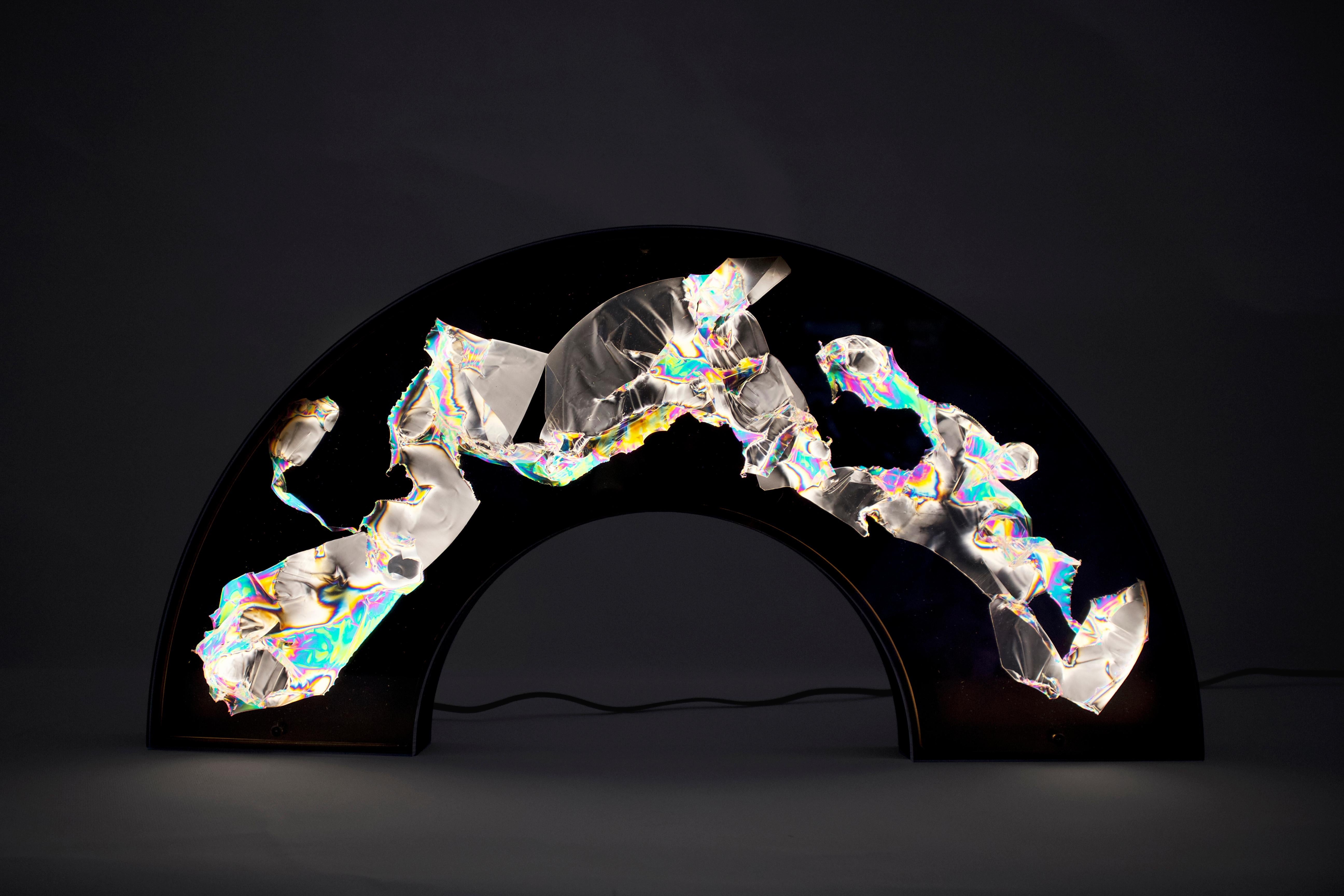 Wall lamp IV by Kajsa Willner
Dimensions: 30 x 60 x 4 cm
Materials: polarized filters, disposable plastic

Polarized portraits
Polarized portraits is a set of wall lights and lamps that use polarized light to reveal stress patterns in clear