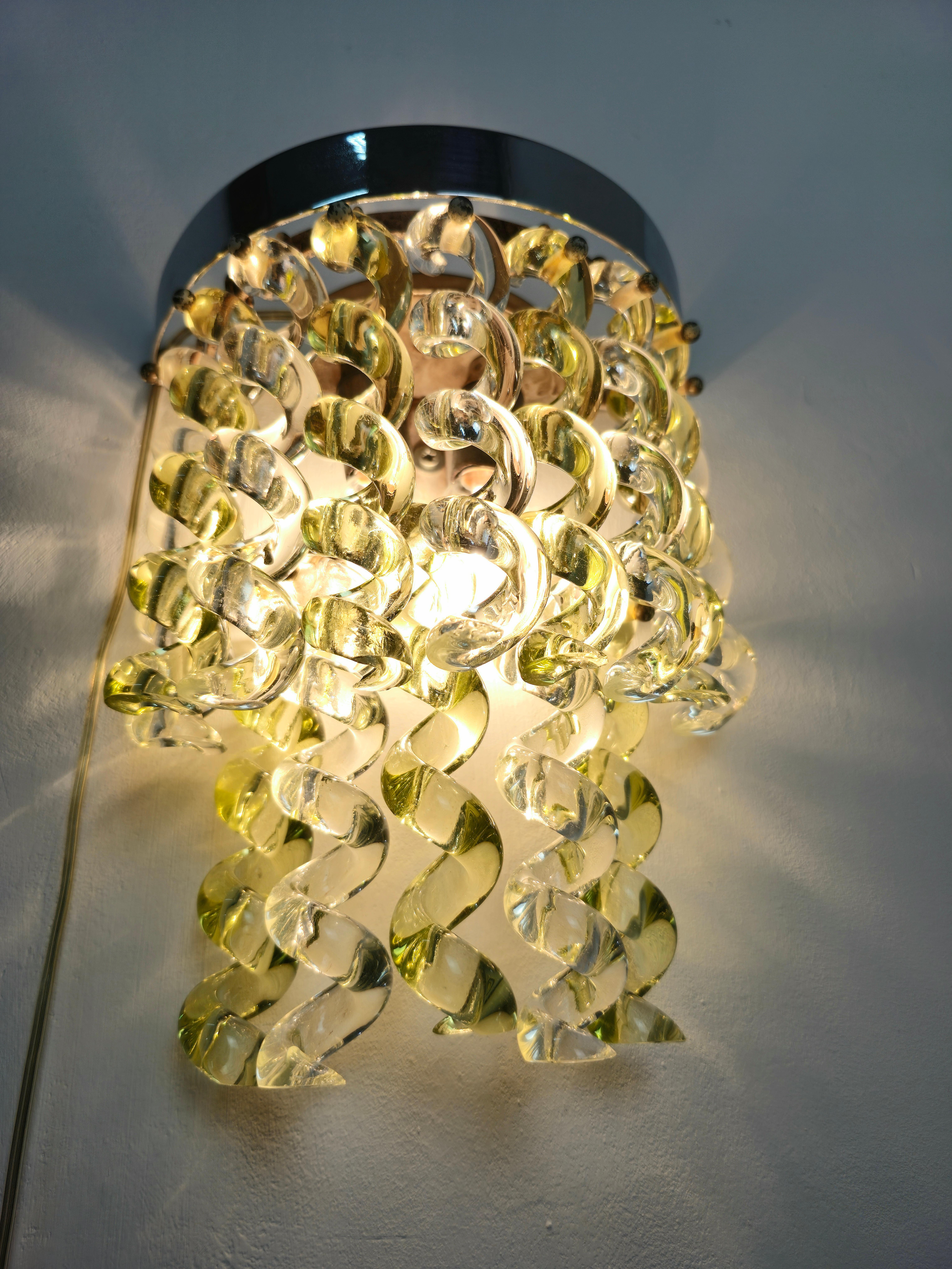 Applique à deux lumières, structure en acier chromé, diffuseurs avec 14 éléments courbés en verre transparent et vert .divisé en 2 niveaux . Production italienne vers 1970. Veuillez regarder attentivement la vidéo et les photos, merci.

Poids :