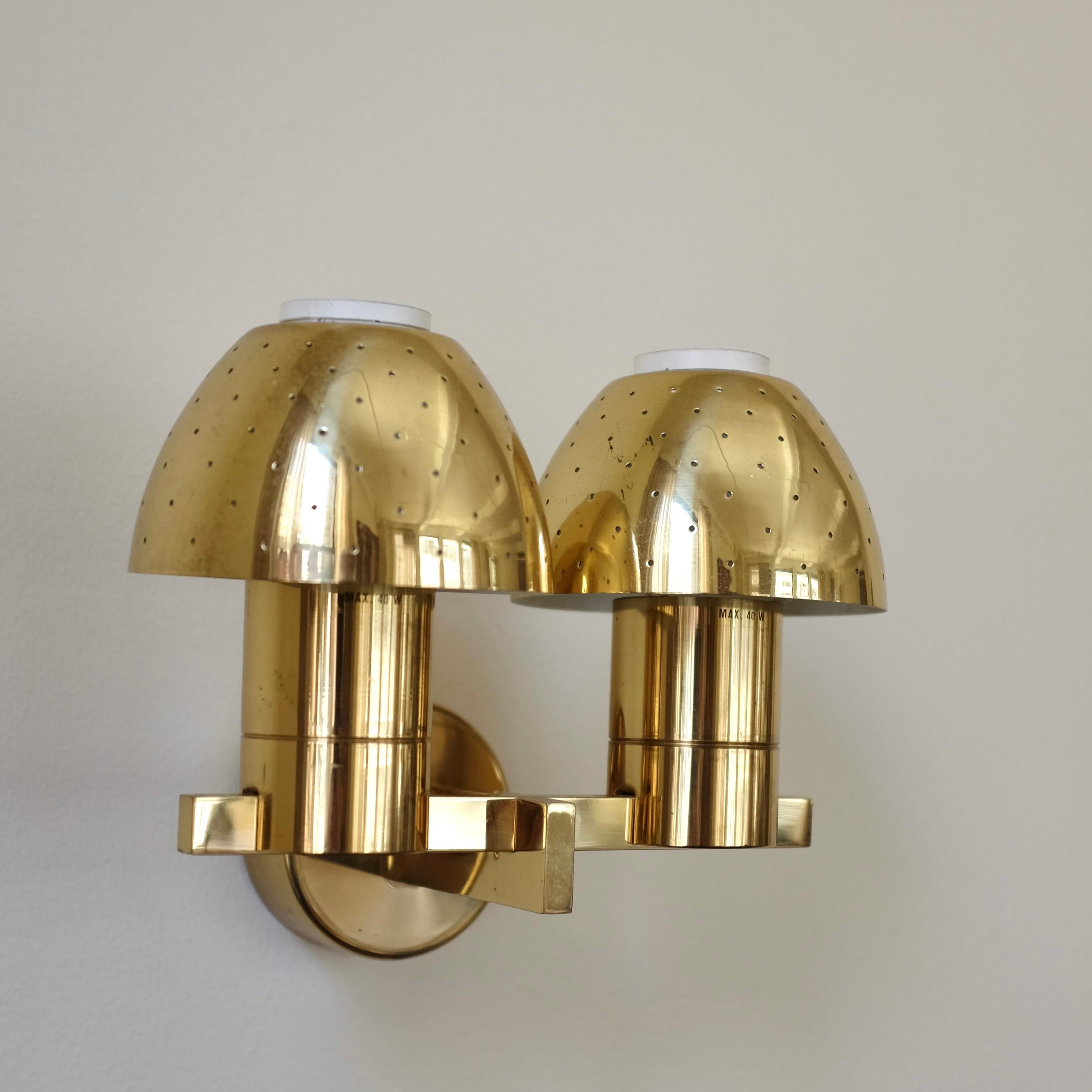 Precioso aplique de latón modelo V306/2 de Hans-Agne Jakobsson, Markaryd, Suecia, con faroles de latón perforado. Este artículo es de principios de la década de 1960 y se fabricó en la propia fábrica de Hans-Agne Jakobsson en Suecia. Pequeña grieta