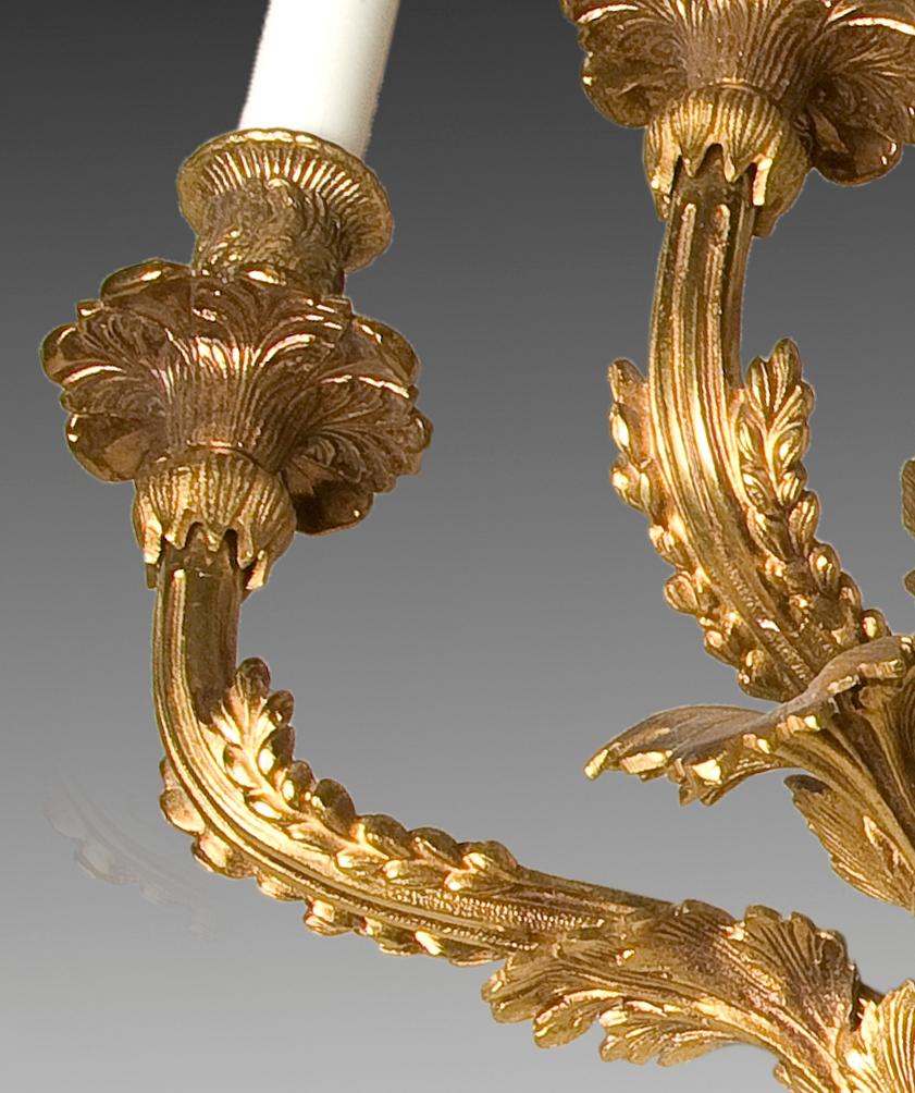 Wall light. Bronze, early 20th century.
 Wall light made of gilt bronze that has three points of light (shaped like a candlestick, remembering when candles were used), and a decoration based on lace, plant and architectural elements of clear French