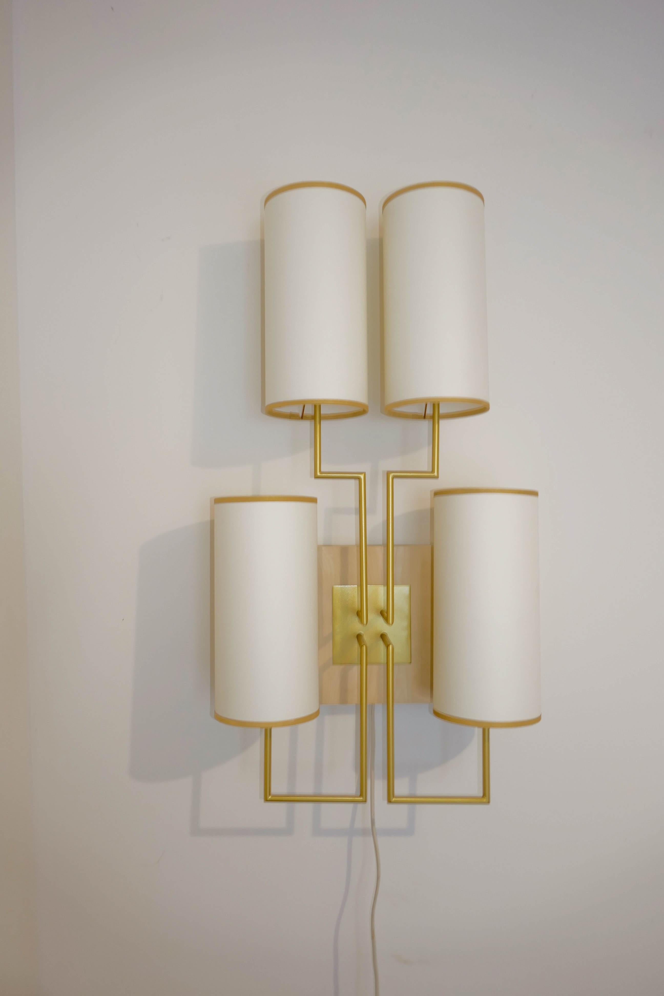 Wall lamp sconce in gold patina and white lamp shades, wooden baze in chestnut. Four lampshade in white fabric and golden braid.