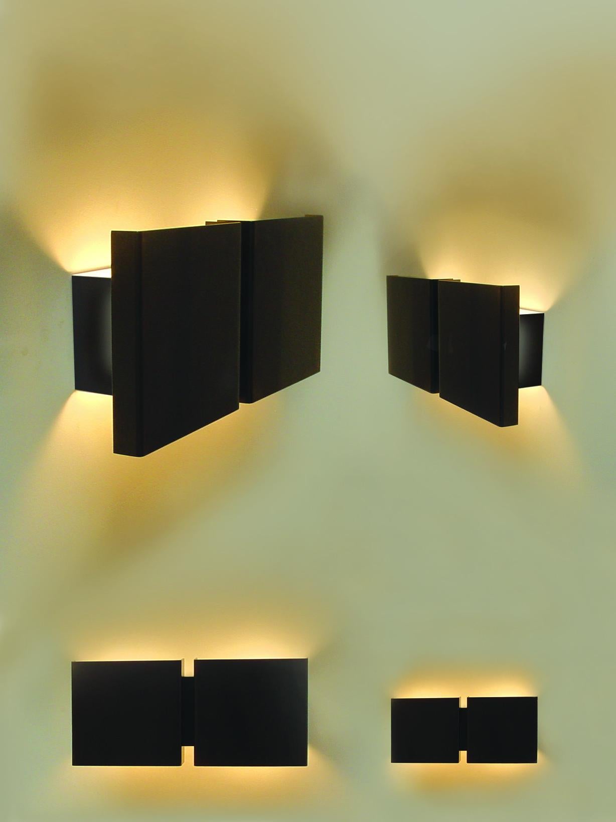 Die Squares 2P Wandleuchte, entworfen von dem renommierten belgischen Innenarchitekten und Designer Christophe Gevers, ist ein Beispiel für sein Talent, geometrische Präzision mit zeitgenössischer Ästhetik zu vereinen. Wahrscheinlich ist es die