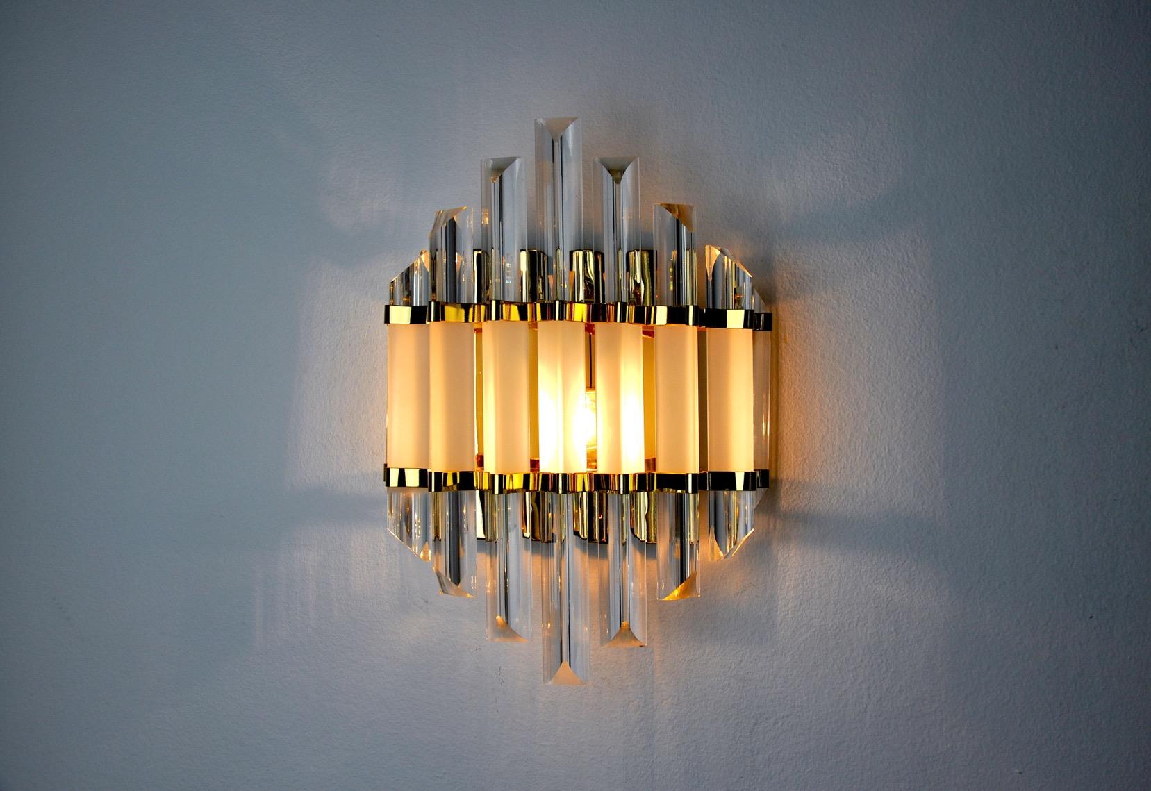 Precioso aplique Venini de los años 70. Estructura de cristal de Murano y metal dorado. Objeto único que iluminará y aportará un auténtico toque de diseño a tu interior. Electricidad comprobada, marca del tiempo relativa a la antigüedad del objeto.