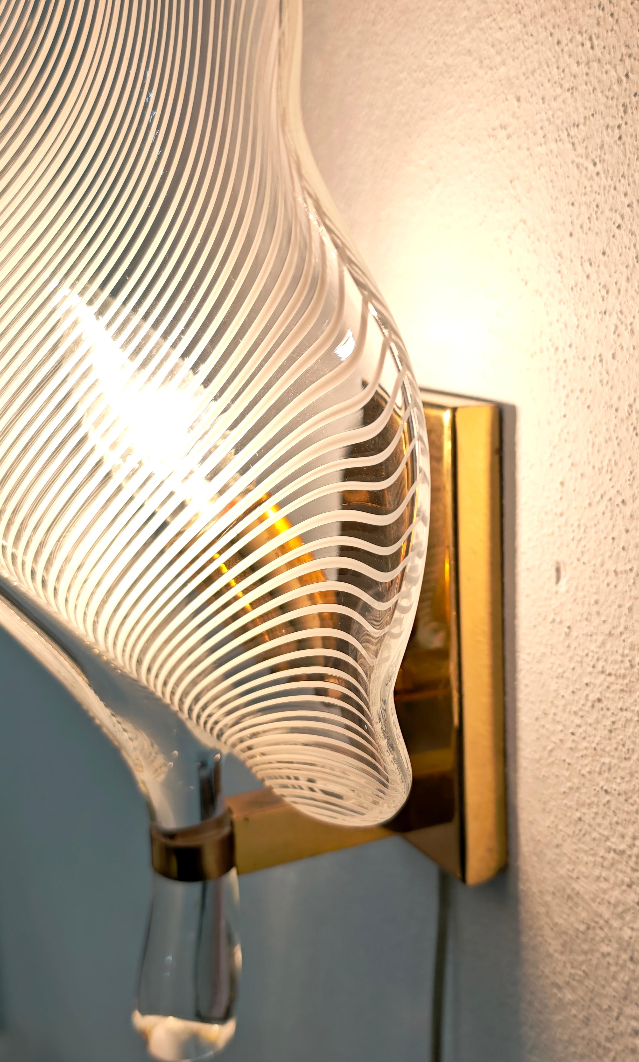 FRANCO LUCE
Made in Murano, Italy, circa 1970
One-light wall lamp with a brass frame and a leaf-shaped diffuser in transparent, colorless, and milky-white half-filigree blown glass. Please watch the video and photos carefully, thank you.

1 light: E