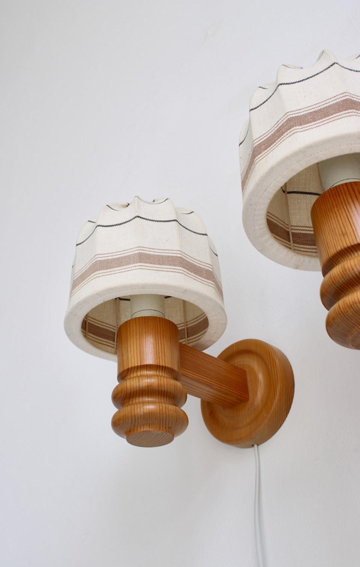 A pair of vintage pine and fabric wall lights designed and produced by Solbackens Svarveri, Sweden in the 1970s. Very good original condition.