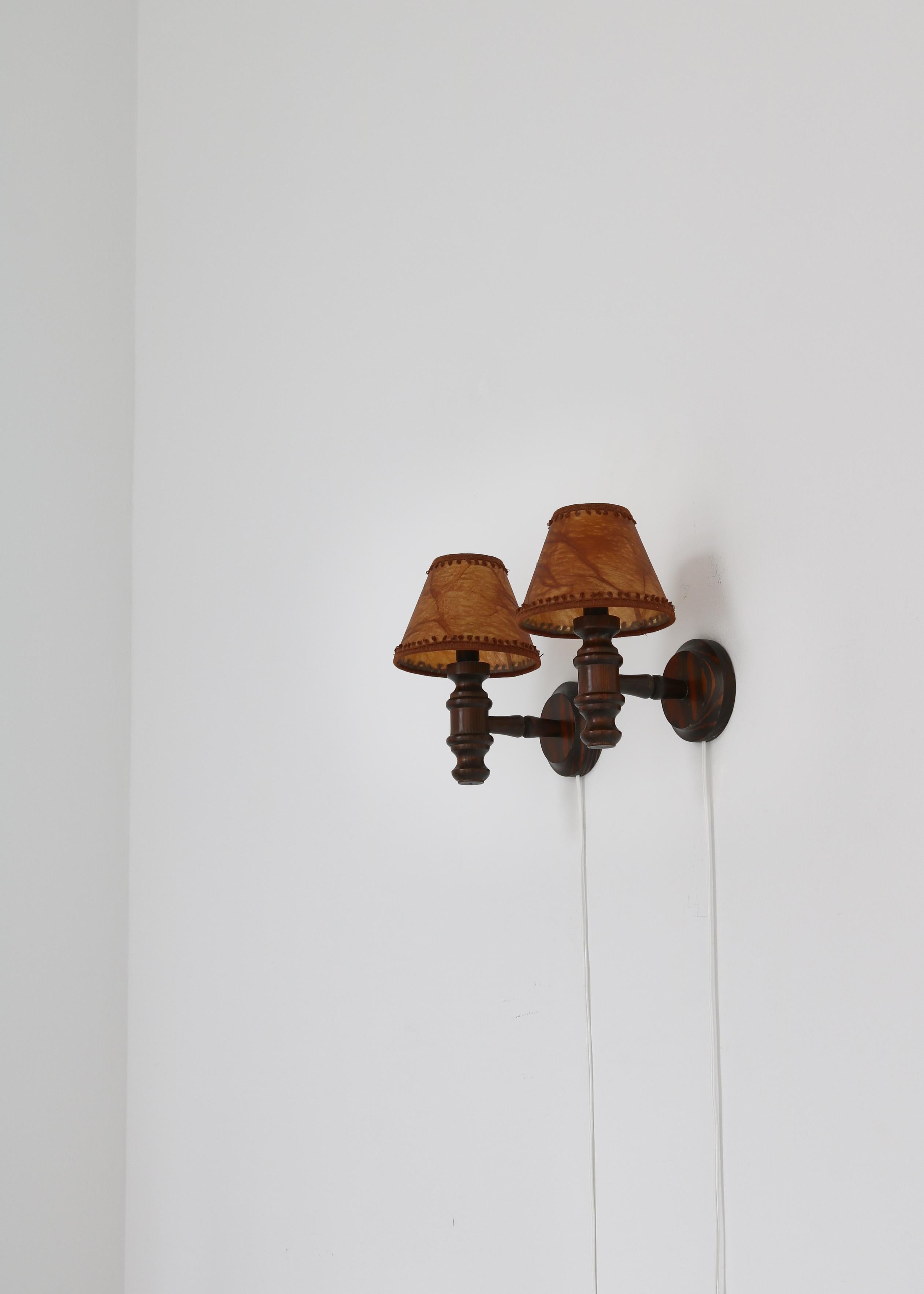 A charming pair of vintage dark stained pine and faux leather wall lights made in Denmark in the 1950s.