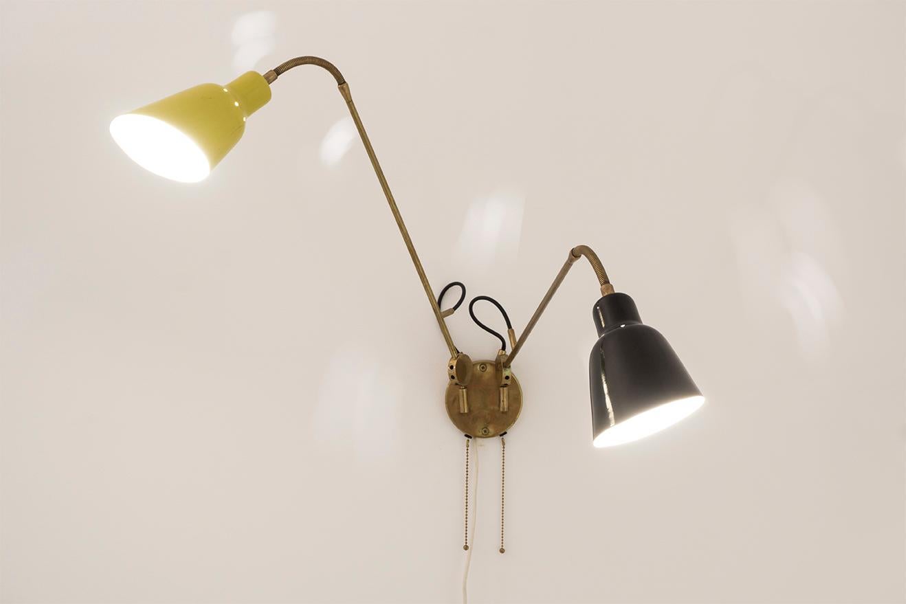 This wall light was designed by the Italian designer Angelo Lelii around 1950.
Made from a brass construction with flexible arms. The reflectors are made of yellow/black lacquered aluminum.