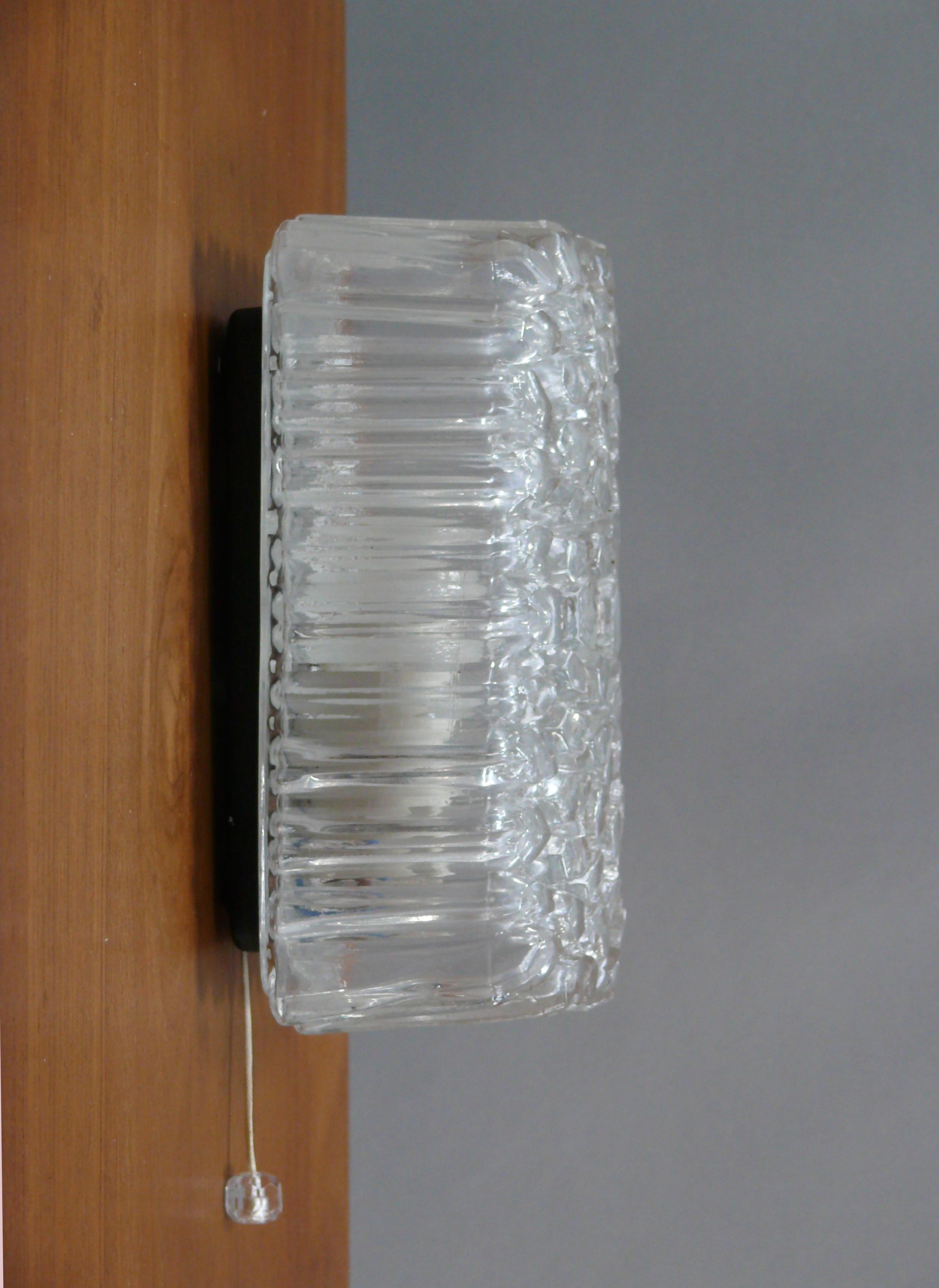 Applique / lampe miroir en verre glacé des années 1960 de Glashütte Limburg - modèle 3040. La lampe est dotée d'un lourd abat-jour rectangulaire avec une structure en verre glacé. La lampe est vissée au mur à l'aide d'un support en verre métallique
