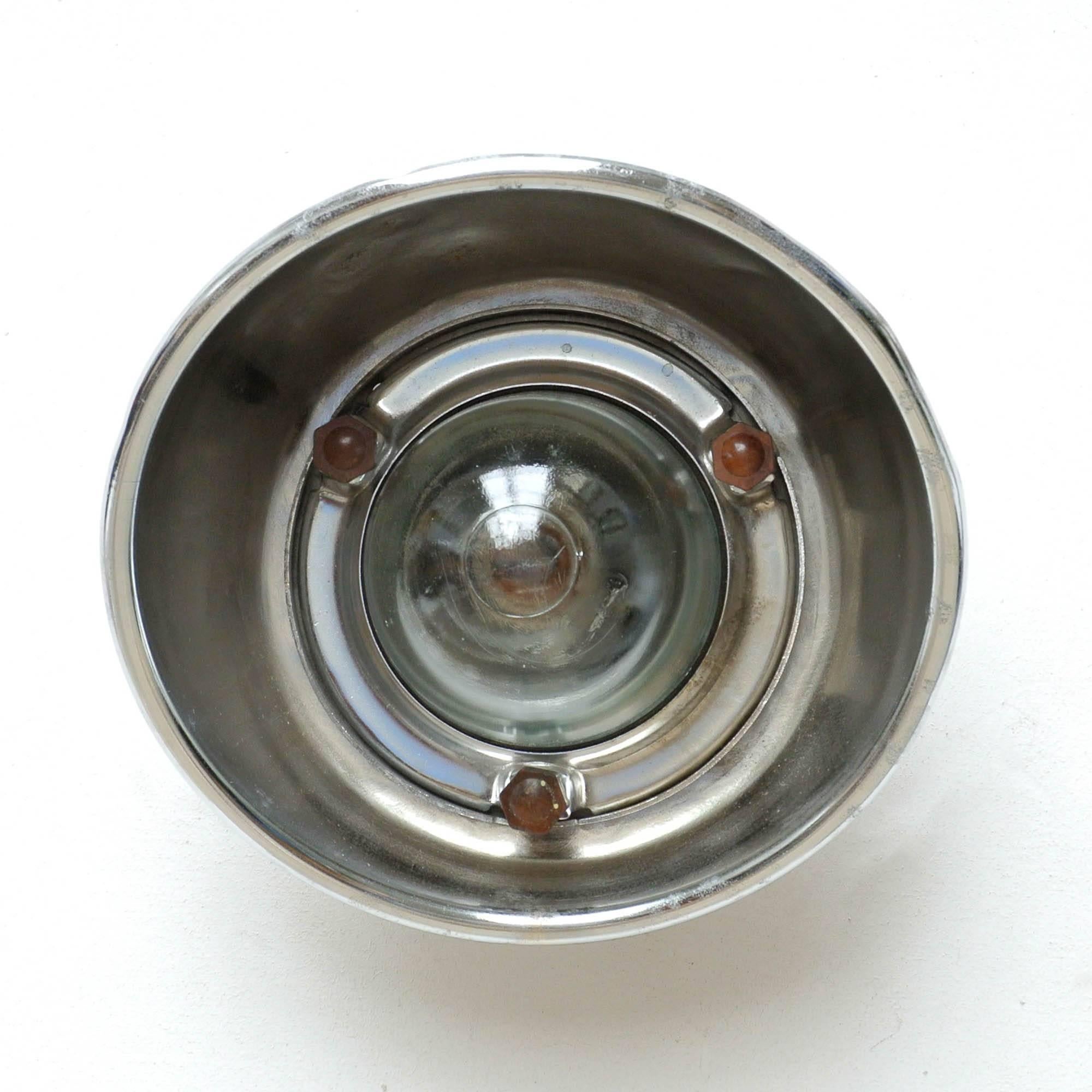 Outdoor old industrial wall light, formerly used for door top. Made of chrome steel, thick transparent glass protected by a fence (fixations in bakelite).

      