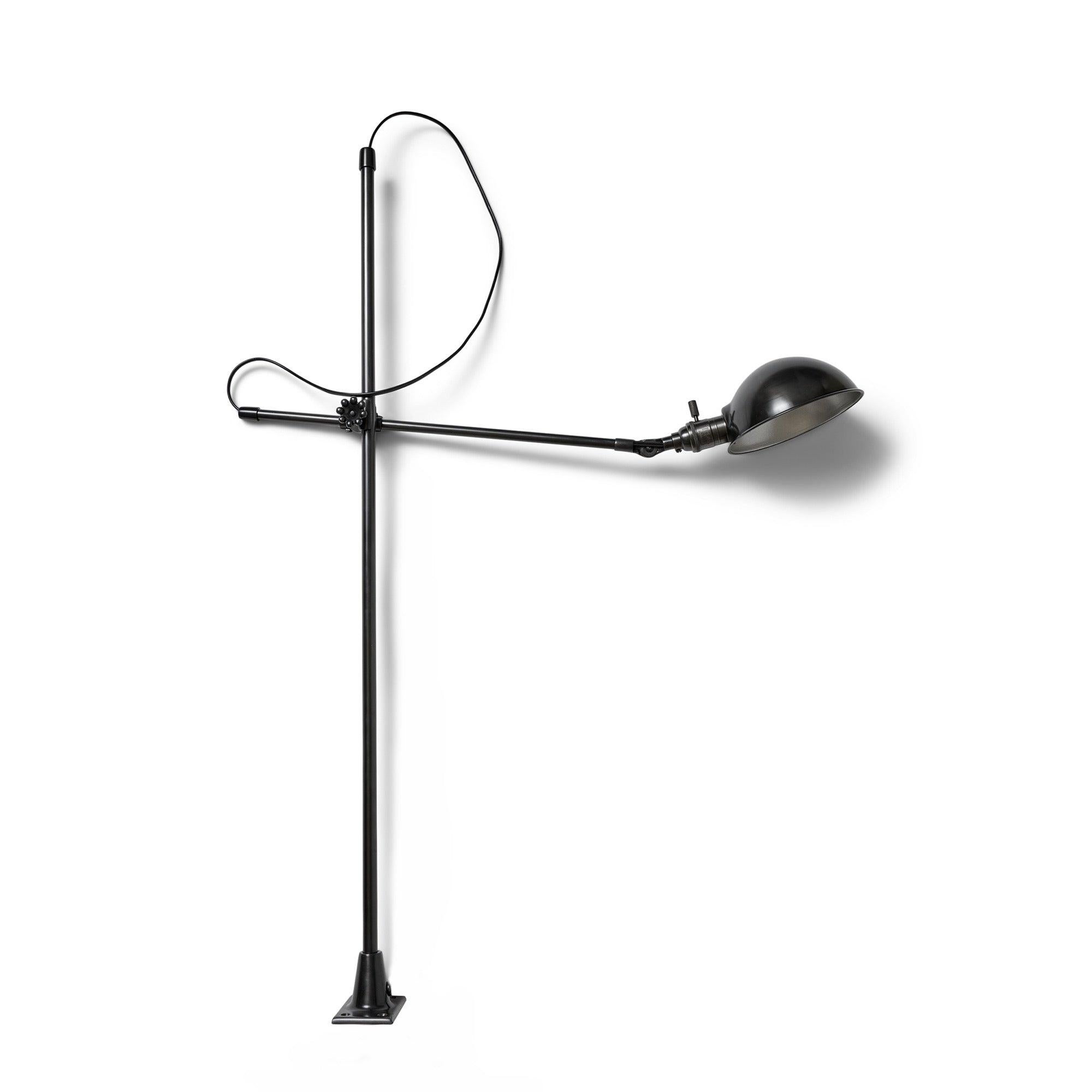 Wandleuchte aus patiniertem Stahl mit rechteckigem Flansch und festem horizontalen Arm, der einen verstellbaren Arm mit gewölbtem Schirm trägt.