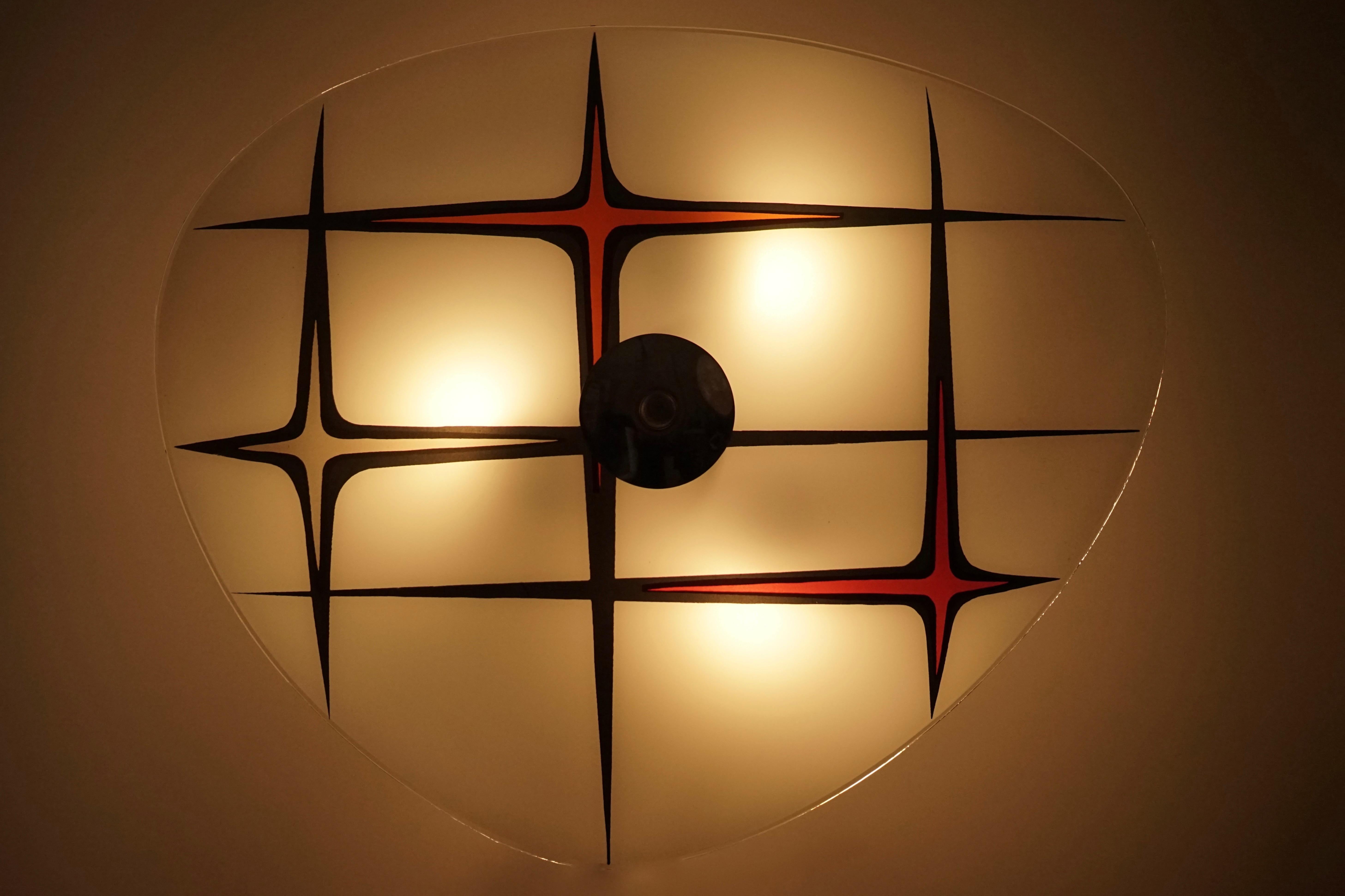 Lampada da parete in vetro di deisgnfornication. Questo è il nostro design basato su piatti di vetro vintage, la cui produzione è iniziata nel 1956 in Cecoslovacchia.
Questa versione è caratterizzata da un motivo nero, bianco e rosso.
La lastra di