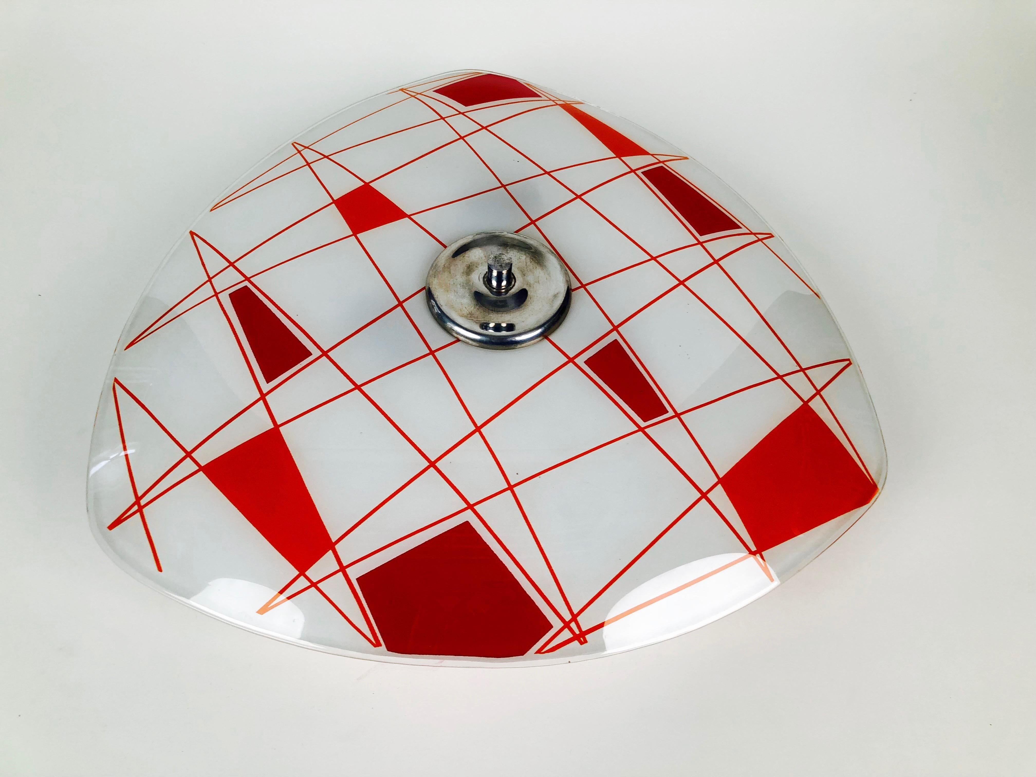 Lampada da parete in vetro di designfornication. Questo è il nostro design basato su una lastra di vetro vintage, prodotta in Cecoslovacchia nel 1956.
Questa versione è caratterizzata da un motivo rosso e arancione.
La lastra di vetro è fissata a