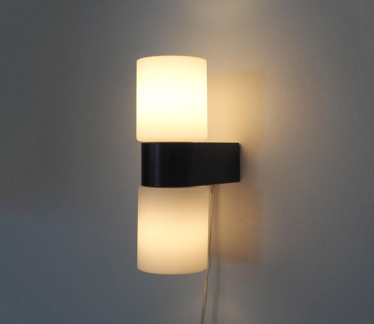

About This Piece

Vintage Design
1960s wall lamp with 2 milk glass shades by Raak Amsterdam.

The caps are attached to a black and white lacquered metal holder with an on-off switch.

Beautiful sleek design and fits in a modern, classic or vintage