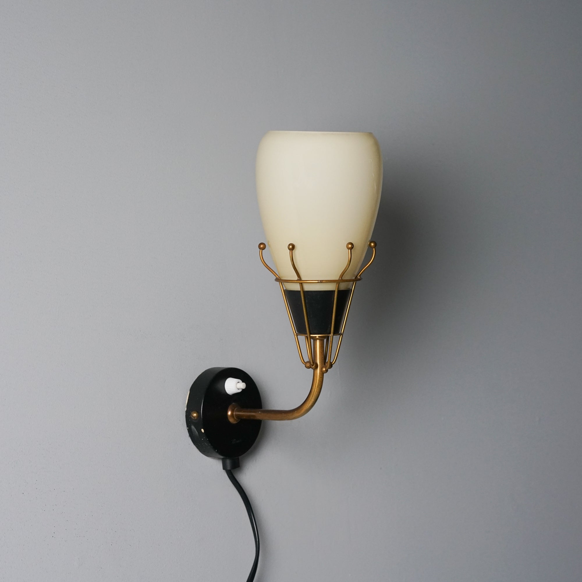 Wall light, designed by Maria Lindeman, manufactured by Idman Oy, 1950s. Opaline glass shade, brass and painted metal frame. Good vintage condition, minor patina consistent with age and use. 