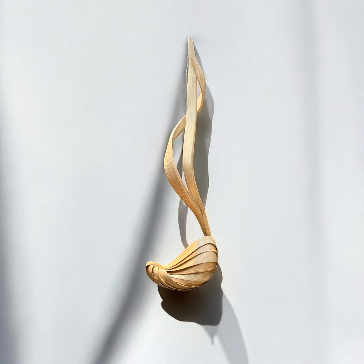 L'applique n. 001 ha un design a forma libera; il legno si piega e si incurva con bellissimi flussi per creare il design. I dettagli artigianali del pezzo, come le curve, lo spessore variabile del legno e le torsioni, conferiscono al pezzo i suoi