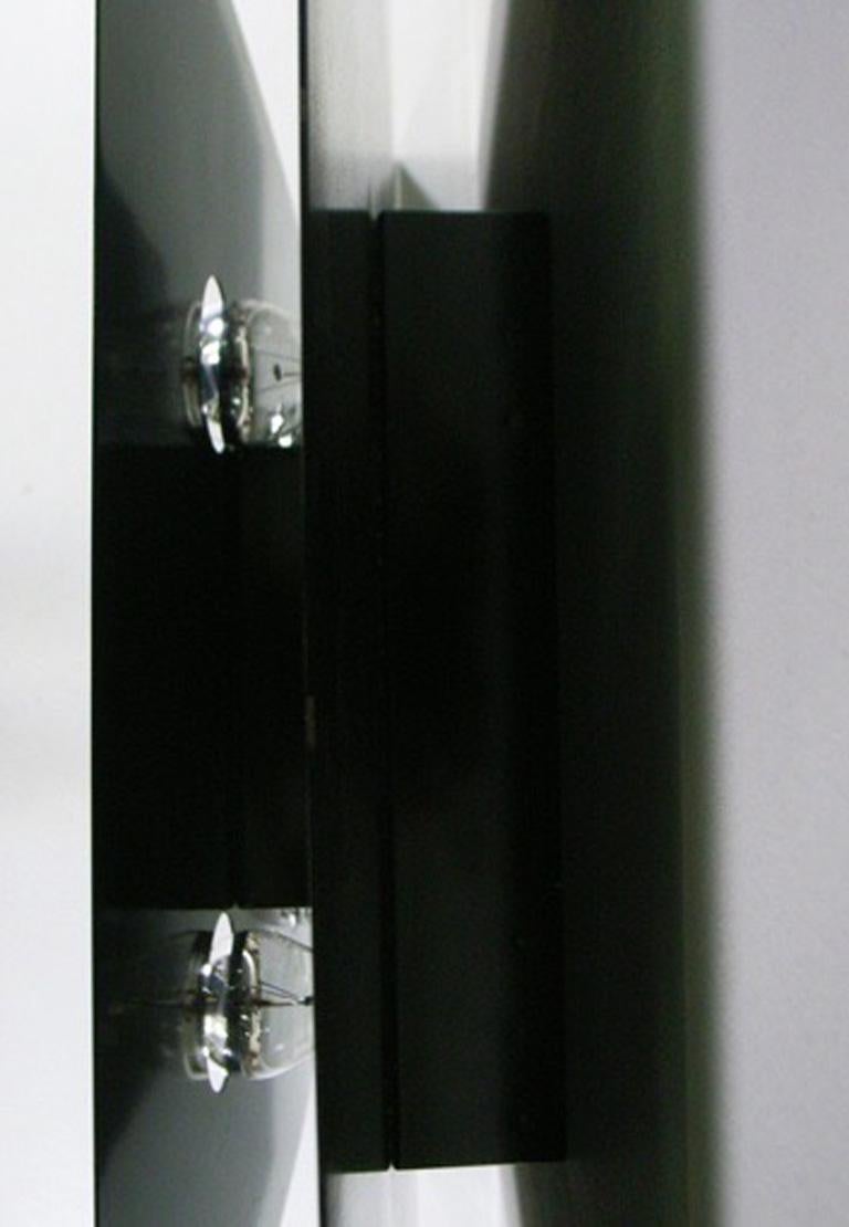 Wall-light object model 'Screen', by Fabrizio Cocchia and Gianfranco Fini, with two metal surfaces painted black and four mirrored light bulbs
Manufactured by New Lamp Roma, circa 1970.