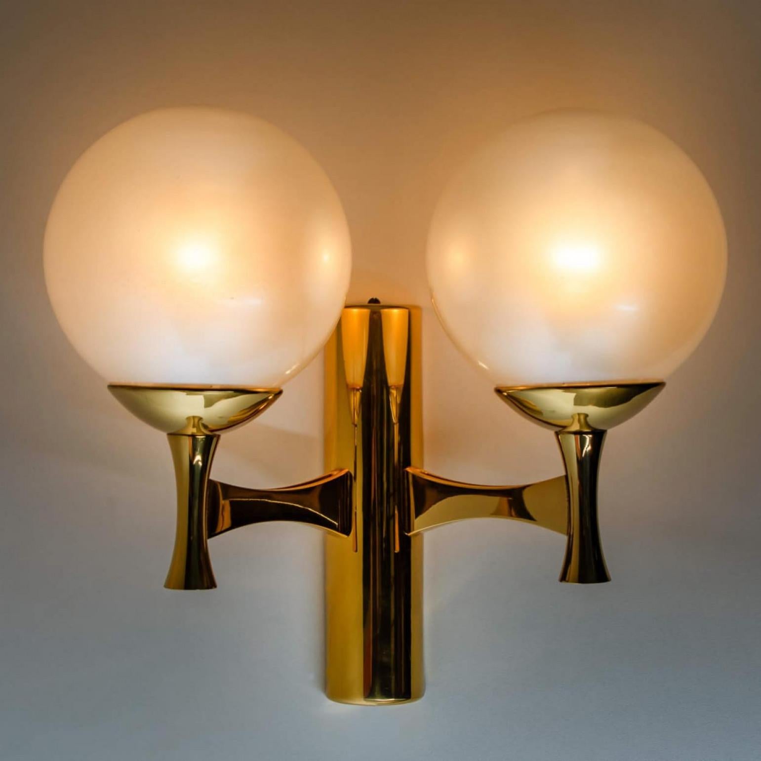 1 der 4 Wandleuchten aus Messing und Opalglas, Europa, 1960er Jahre.

Die Wandleuchte besteht aus 2 Opalglaskugeln. Durch die Kombination der Materialien erzeugen diese Leuchten ein schönes warmes und diffuses Licht. Entworfen im Stil von