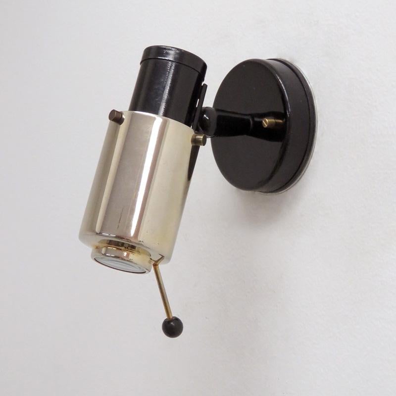 Pair of brass and black enameled wall lights by Jacques Biny for Lita with magnifying lens, handle to adjust angle and direction, provision for on/off pull switch, partially marked, wired for US standards, one E12 socket each, max. wattage 60w or