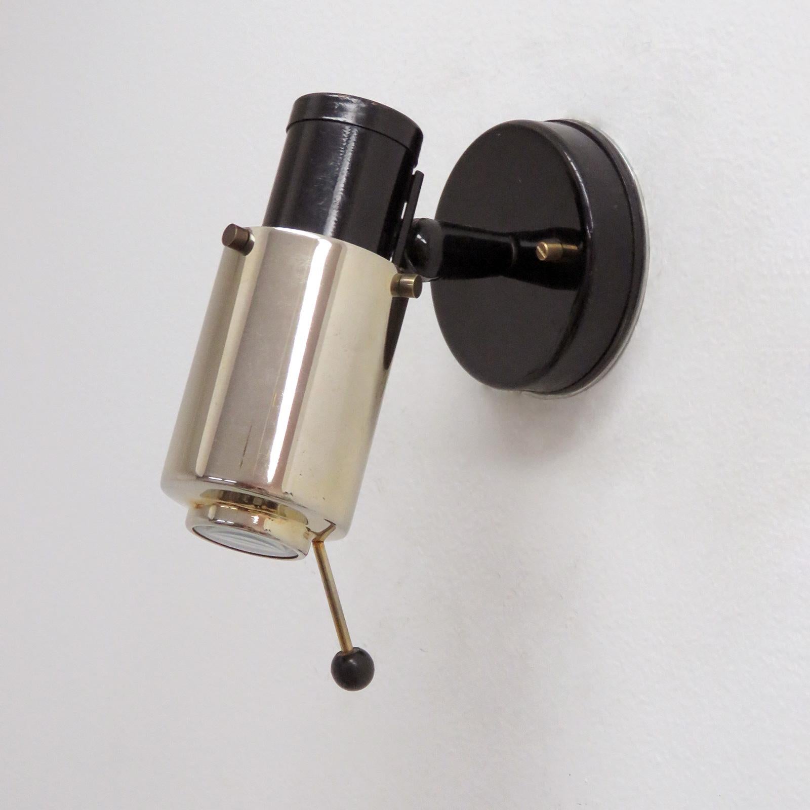 Pair of brass and black enameled wall lights by Jacques Biny for Lita, with magnifying lens, handle to adjust angle and direction, provision for on/off pull switch, partially marked, wired for US standards, one E26 socket each, max. wattage 60w or