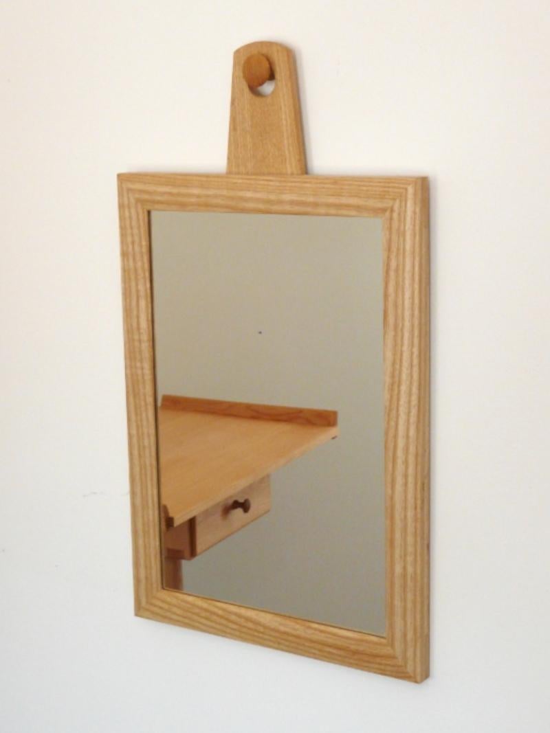 Cet exquis miroir mural suspendu est doté d'un magnifique cadre artisanal en bois de frêne, dont les profils doucement arrondis lui confèrent un aspect à la fois raffiné et naturel. Les coins du cadre sont méticuleusement construits à l'aide