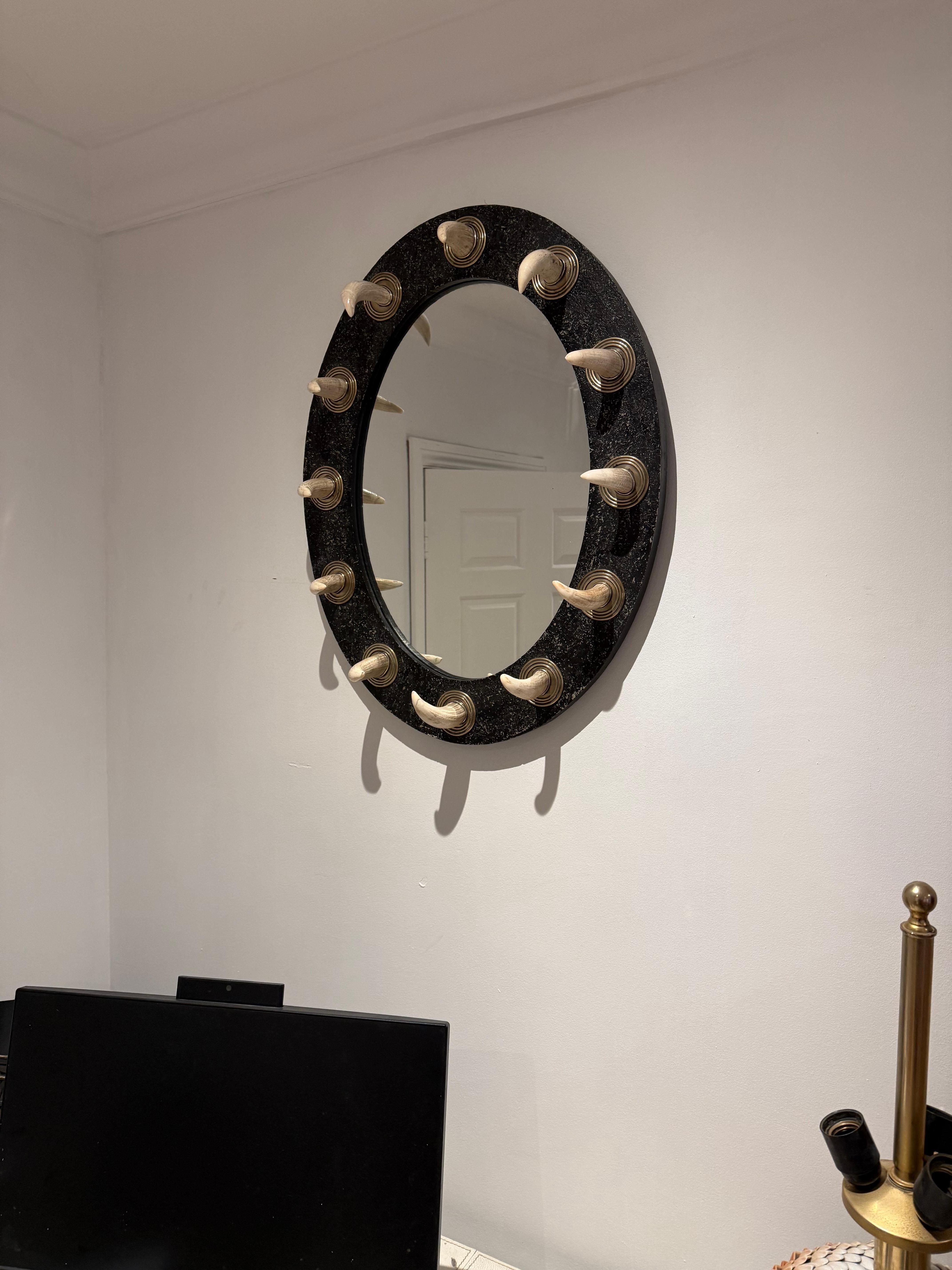 English 70's mirror attributed to Anthony Redmile, frame made lacquered wood, polished metal rings and attached Walrus tusks.