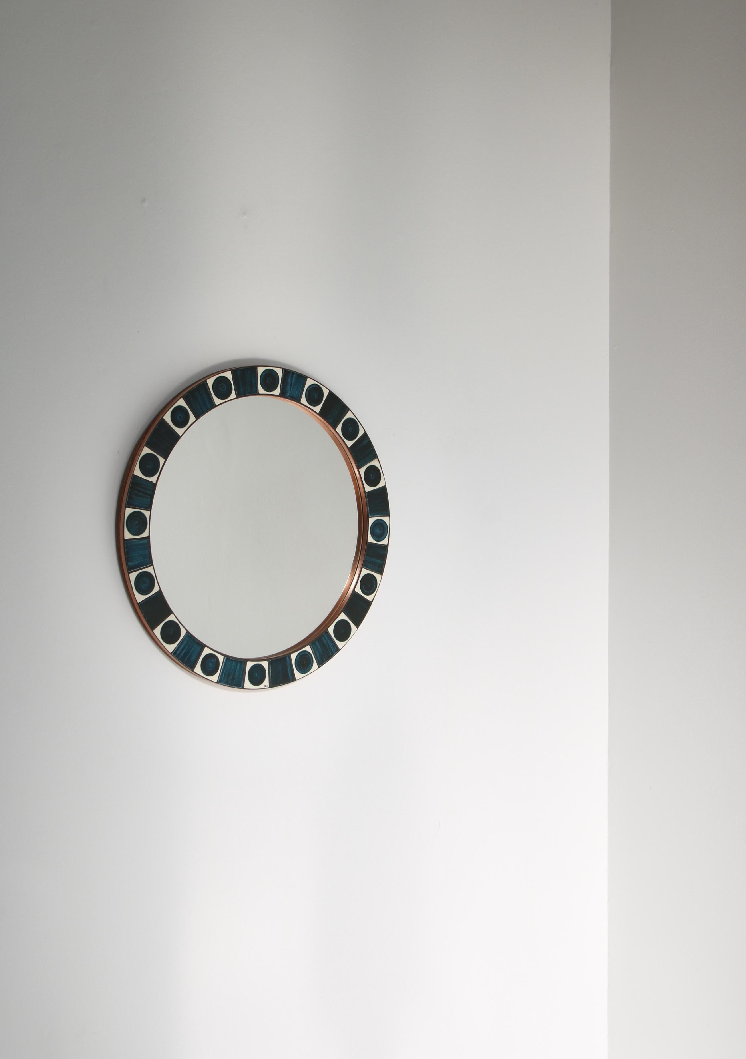 Beautiful wall mirror with blue decorated ceramics tiles hand decorated by Dietlinde Hein in the 1960s. Mounted on teakwood with copper strips. The mirror was manufactured by Knabstrup ceramics workshop in Denmark. Signed 