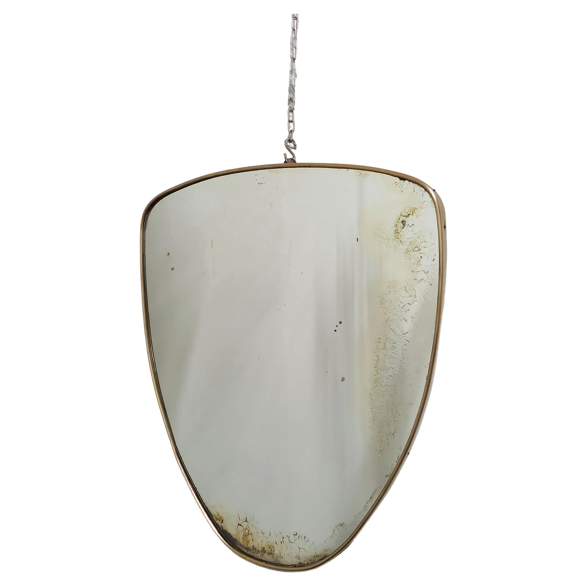Wall mirror with brass frame in the style of Gio Ponti, 1950s. Shield shape, mirrored crystal. Defects in the mirroring. It retains all its original parts.

On request it is possible to replace the worn glass.

Weight: 3950 grams

Note: We try to