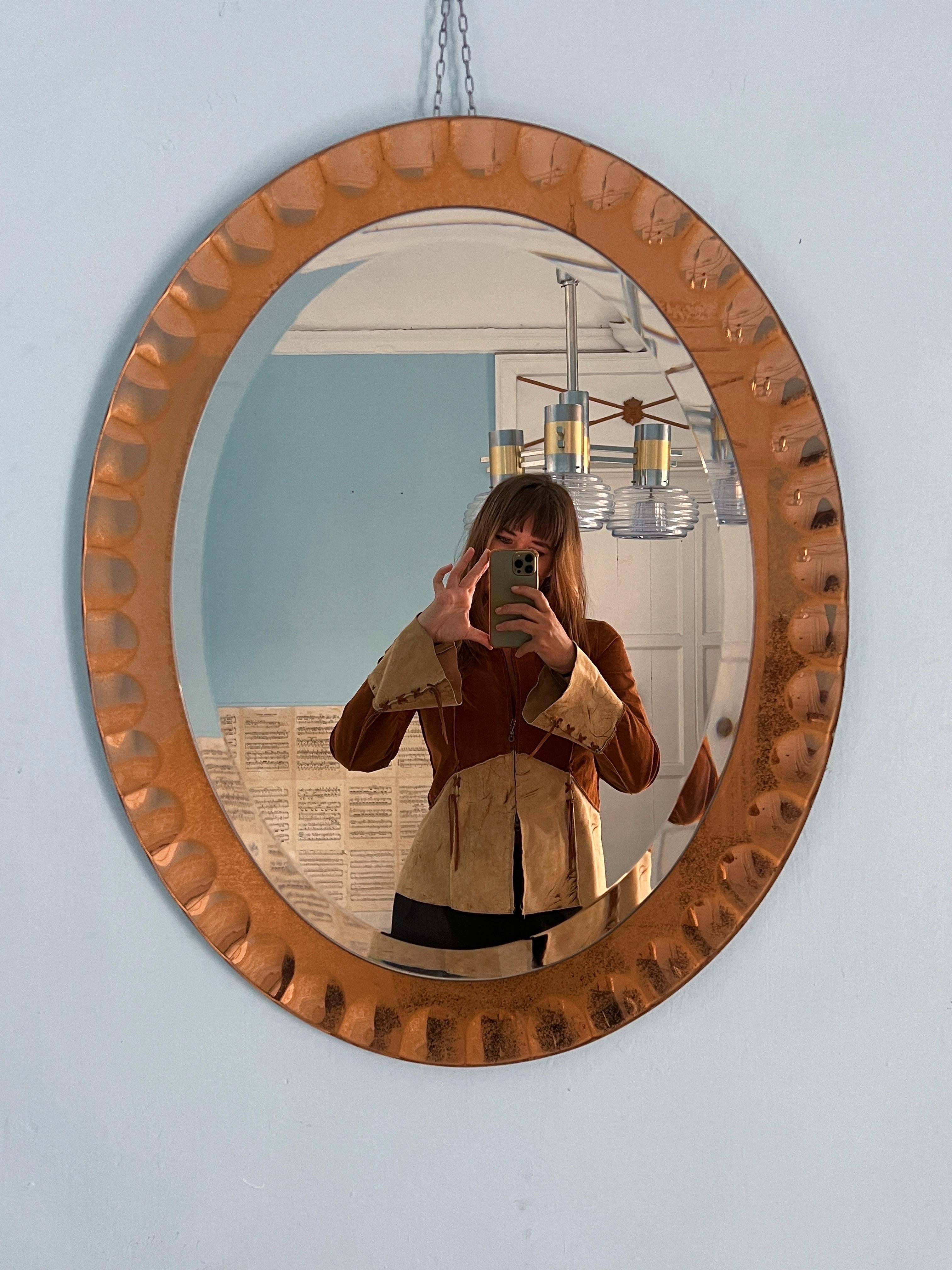 Stunning wall mirror by Crystal Arte, crafted in the 1960s in Torino, Italy. This exceptional piece features a beautiful soft pink frame, adorned with a rich patina that tells the story of its age, complete with unique dark spots. 

The mirror’s