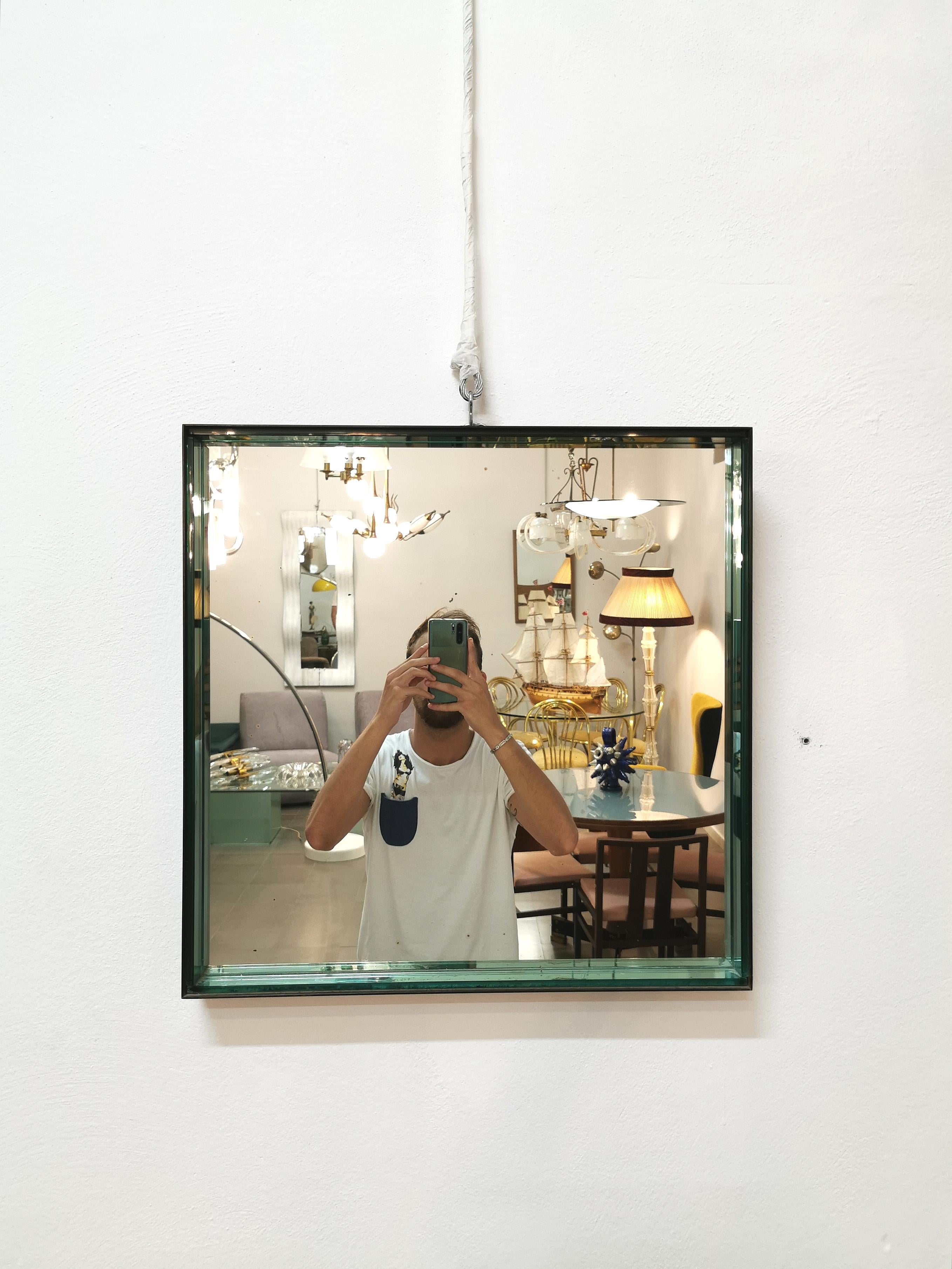 Rare and original Fontana Arte wall mirror mod.1928 in square shape. The structure is in black lacquered metal, inside there is a water green effect glass border. On the structure there are 2 holes for wall accommodation. Made in Italy on January 2,