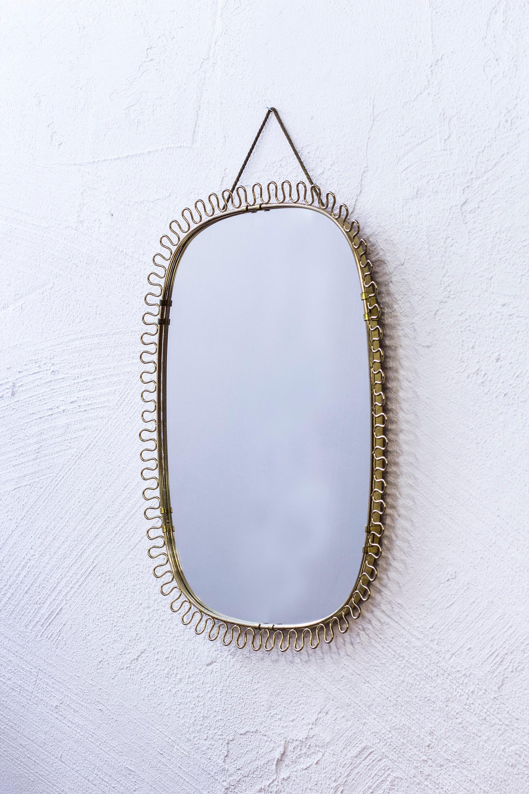 Wall mirror designed by Josef Frank. Produced by Firma Svenskt Tenn during the 1950s. Made from brass with mahogany back part. Excellent condition with very light age related patina and wear.
      
