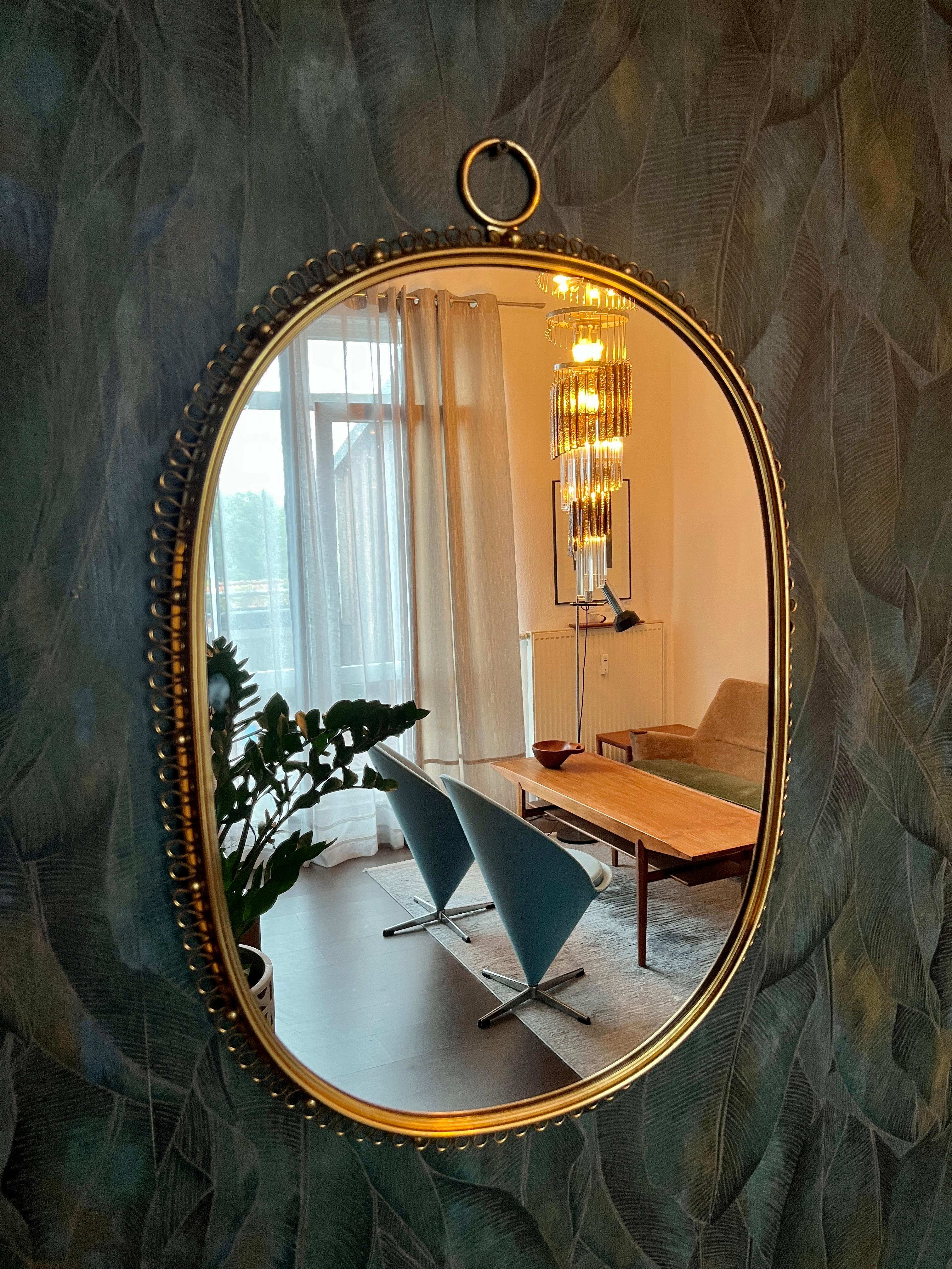 Un grand miroir avec un cadre à boucle en laiton.
Un classique absolu du design des années 1950. Très rare sous cette forme.
Ce miroir en laiton a été conçu par le designer autrichien Josef Franks pour la célèbre société de design suédoise Svenskt