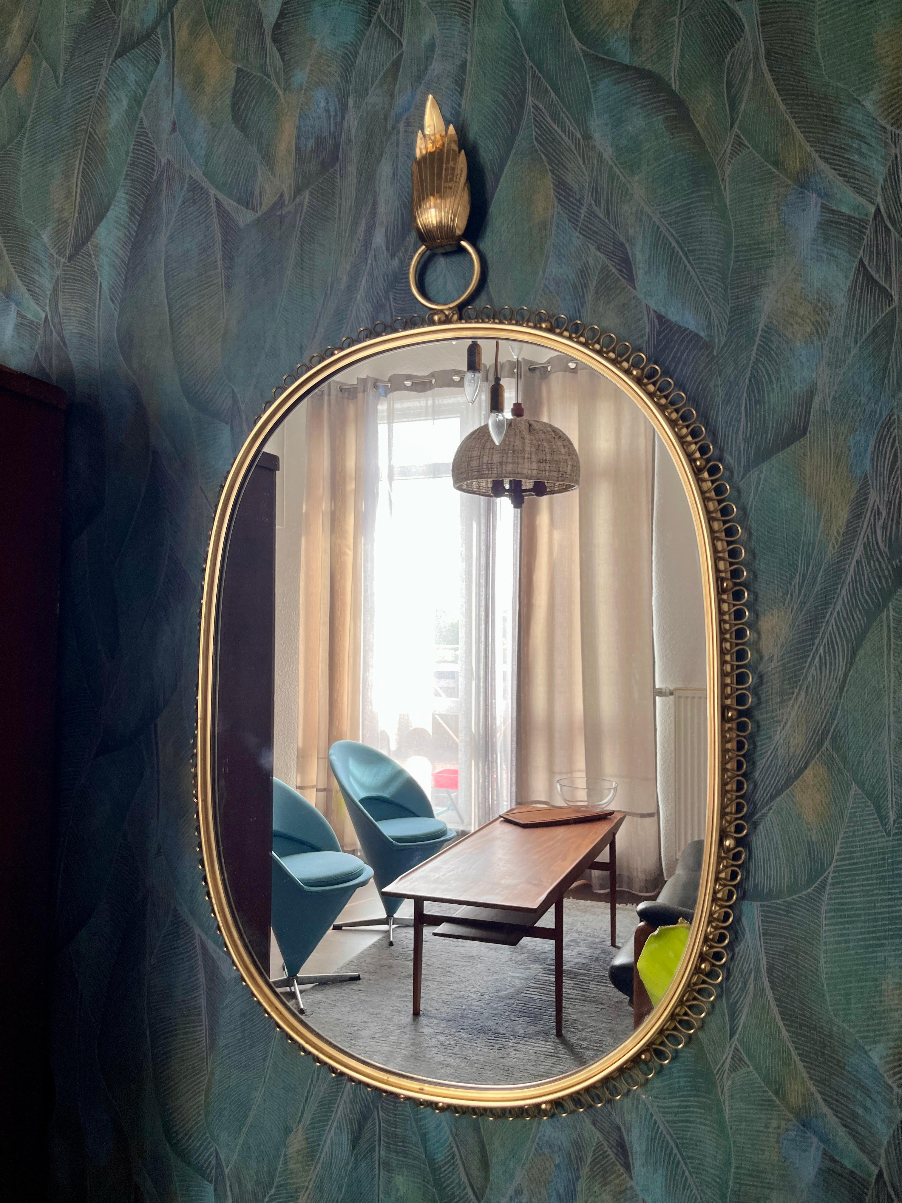 Un grand miroir avec un cadre à boucle en laiton.
Un classique absolu du design des années 1950. Très rare sous cette forme.
Ce miroir en laiton a été conçu par le designer autrichien Josef Franks pour la célèbre société de design suédoise Svenskt