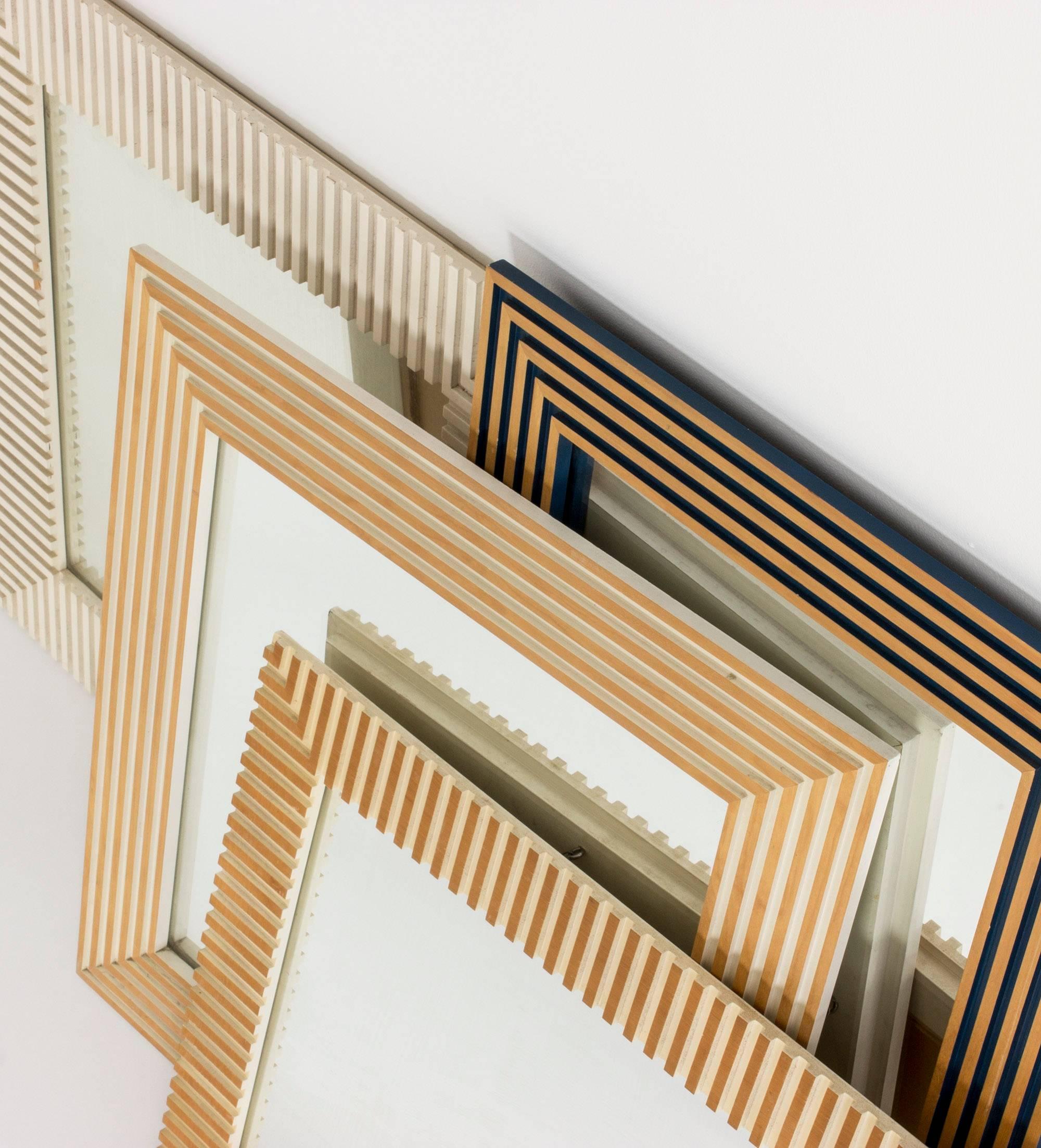 Striking, timeless wall mirror by Susanne Tucker and Maurice Holland, made from wood embossed in a geometrical fashion. Frame lacquered white inside the embossments, with wood exposed on the surface, giving an impression of it being gilded.