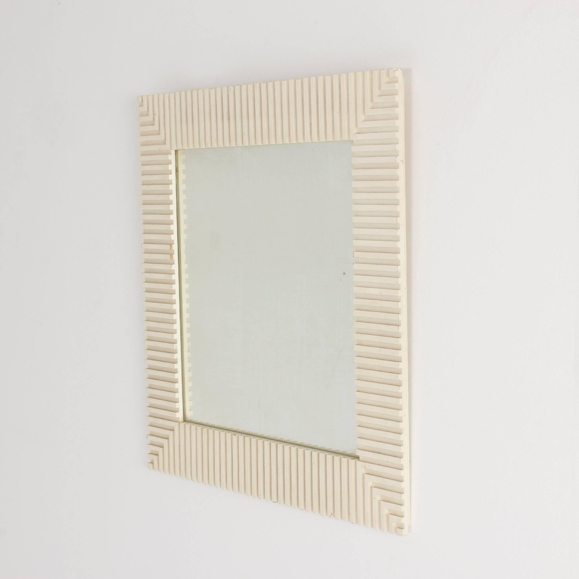 Striking, timeless wall mirror by Susanne Tucker and Maurice Holland, made from wood embossed in a geometrical fashion which gives a cool effect particularly at the corners. Frame lacquered white.