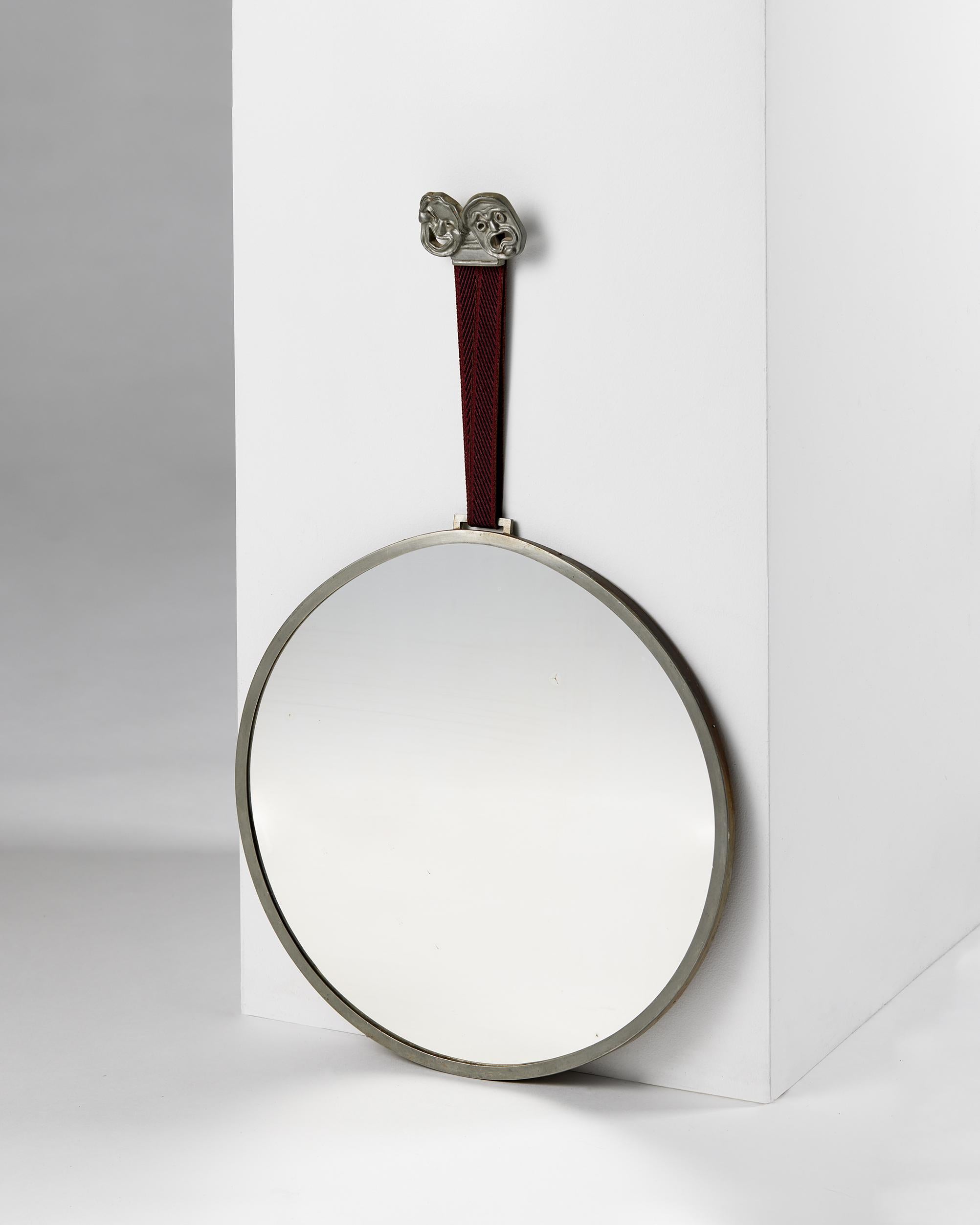 Wall mirror designed by Hans Bergström for Ystad Metall,
Sweden, 1932.

Stamped.

Pewter, textile, and mirrored glass.

H: 57.5 cm
Diameter: 35 cm
