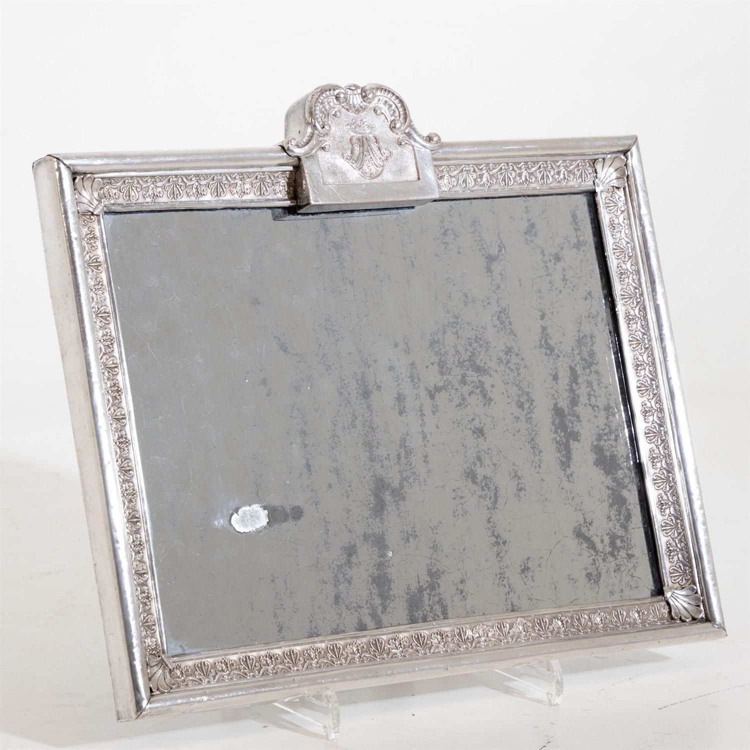 Silver plated metal frame with partly blind mirror glass and monogram in rocaille cartouche. Prov: from the estate of the Barons von Kühlemann-Stumm.