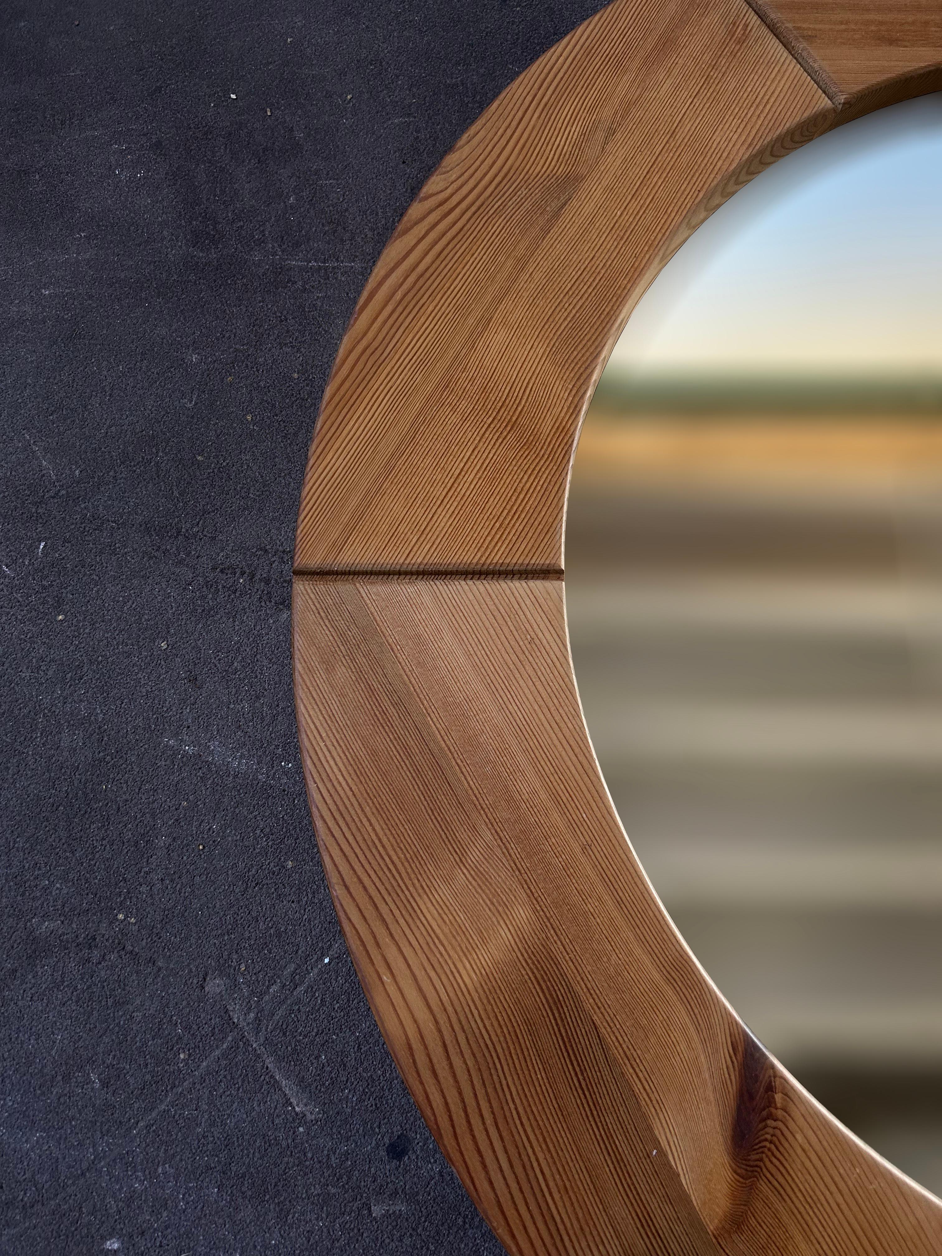 Big round solid pine wall mirror by Swedish manufacture Glasmäster Markaryd in the 1960's.
The mirror is made in beautiful solid pine with a great structure and it has a beautiful natural glow in the wood which gives a great detail to the