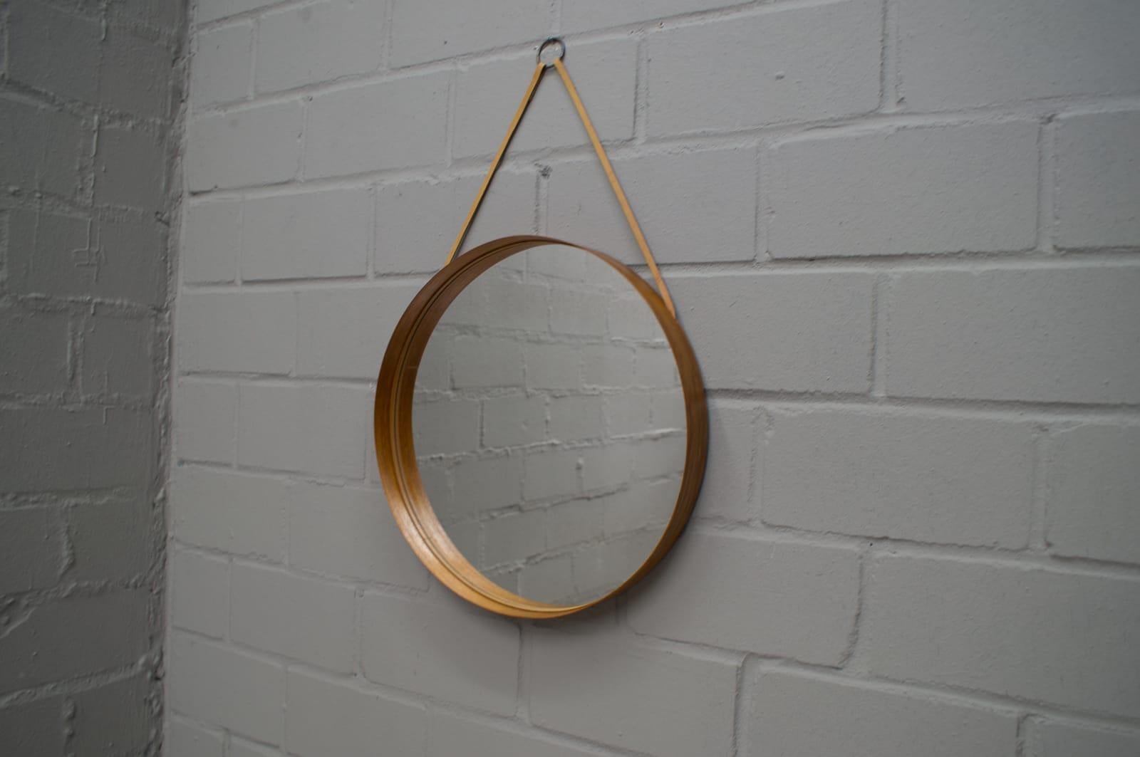 Rare mirror in teak, brass and leather. Produced by Glass Mäster in Markaryd, Sweden. Original 1960s. Teak is with beautiful patina. Original screw with brass head is included.
  