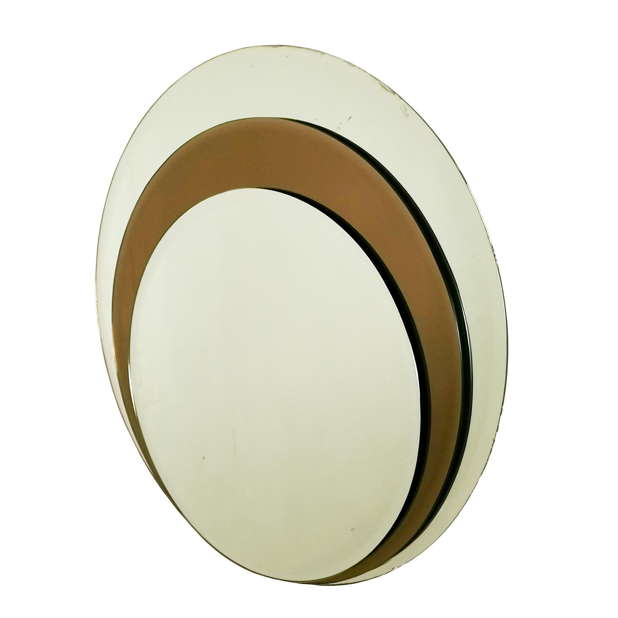 Runder Wandspiegel, bestehend aus drei übereinander angeordneten abgeschrägten Spiegeln, abwechselnd weiß und bronzefarben. Oxidationsspuren an den Rändern.
Italien um 1960.