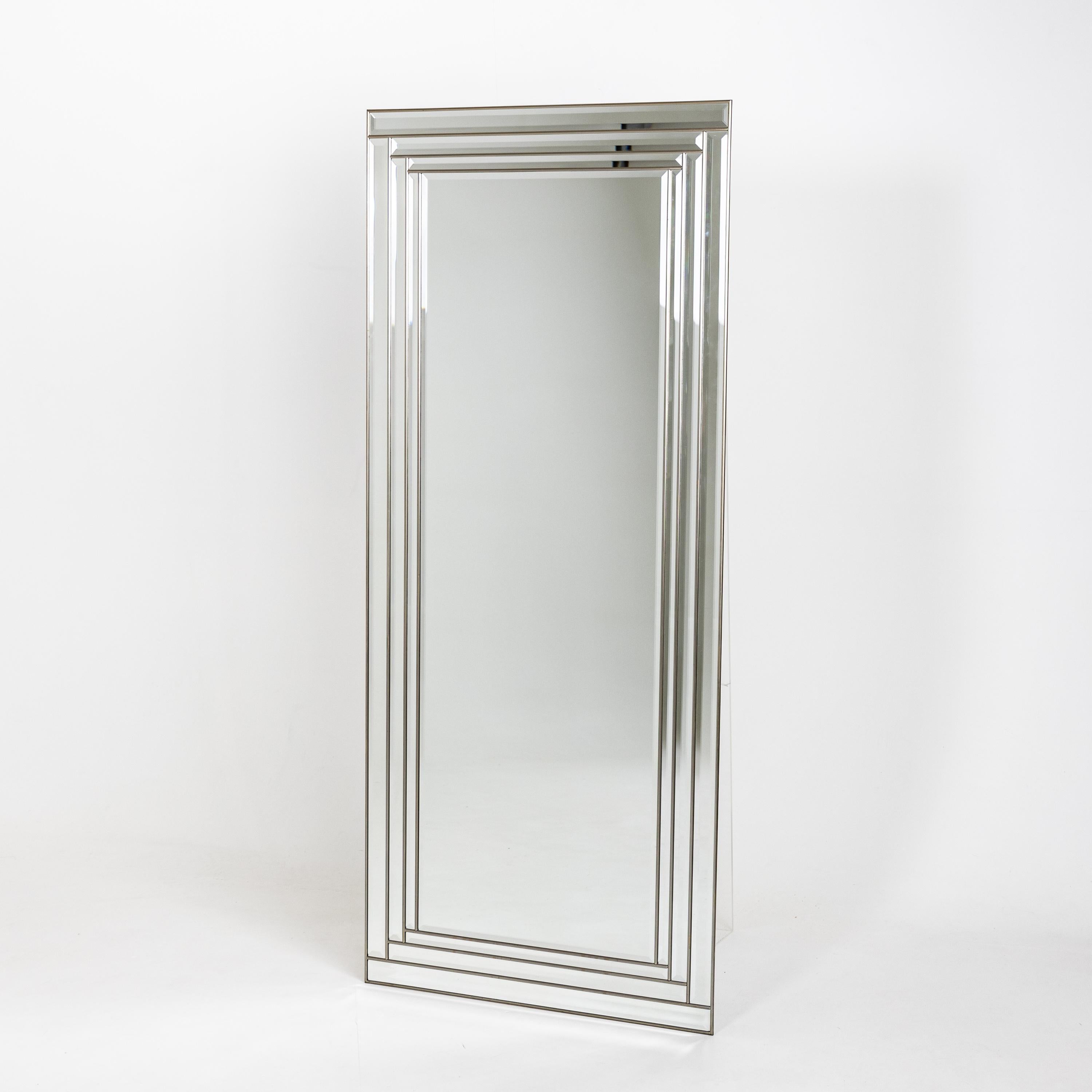 Large wall mirror with triple faceted framing and slender profile.