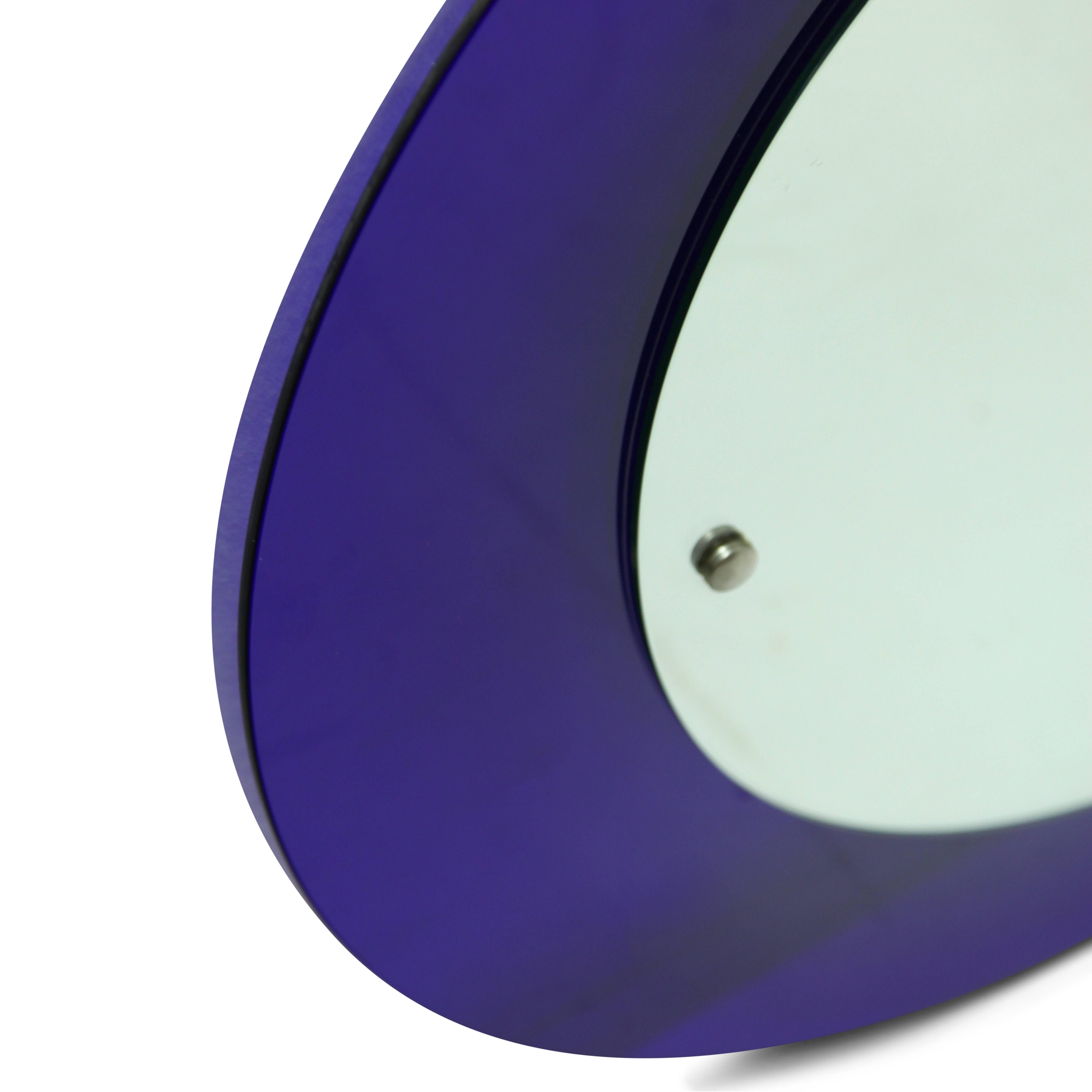 Round wall mirror with a blue glass frame, the mirror pane is slightly off to the right.