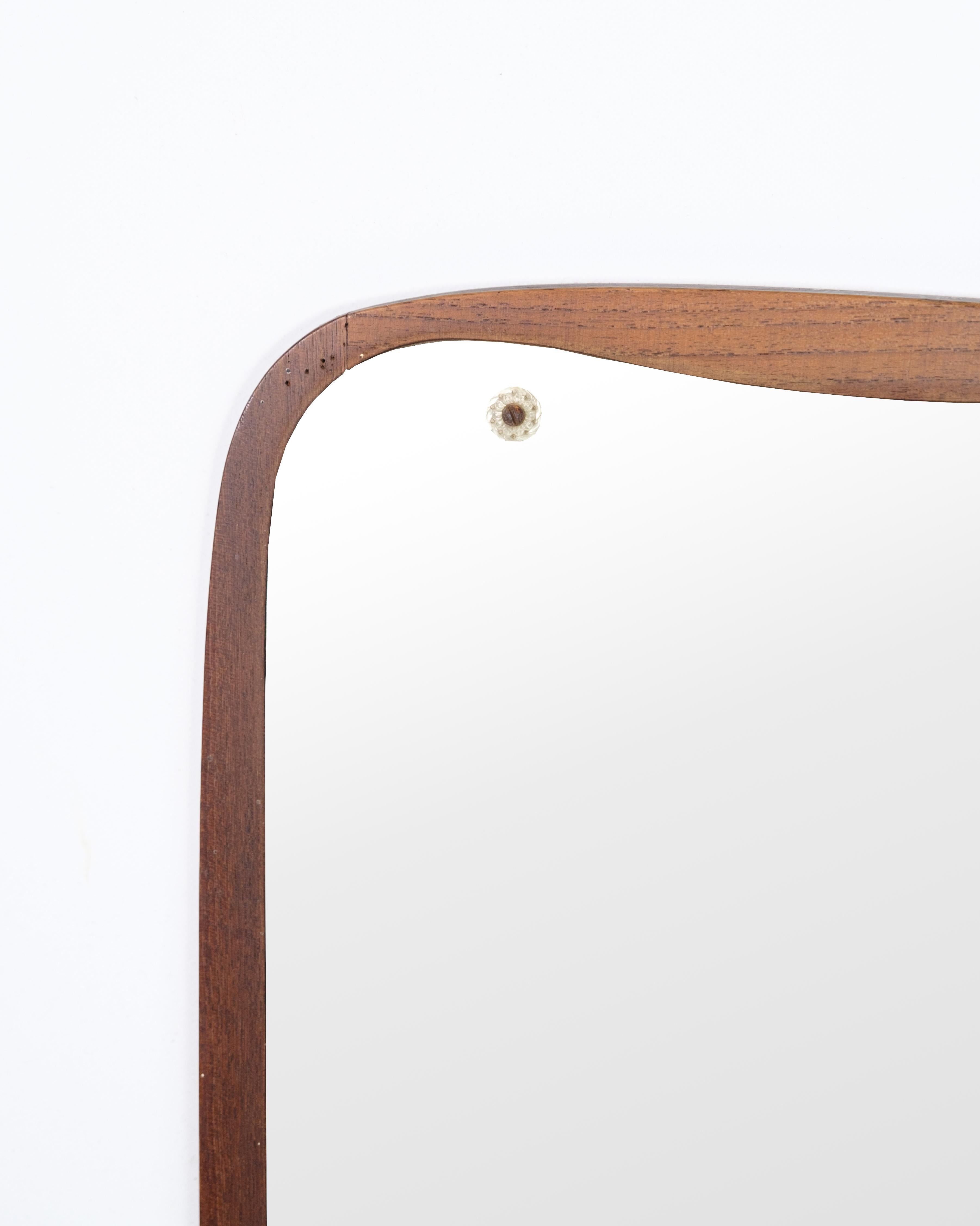 Specchio in teak degli anni '60. La cornice è realizzata in legno di teak, che conferisce allo specchio una luce calda e naturale. Con il suo design semplice e funzionale, questo specchio è un buon esempio di artigianato danese della metà del XX