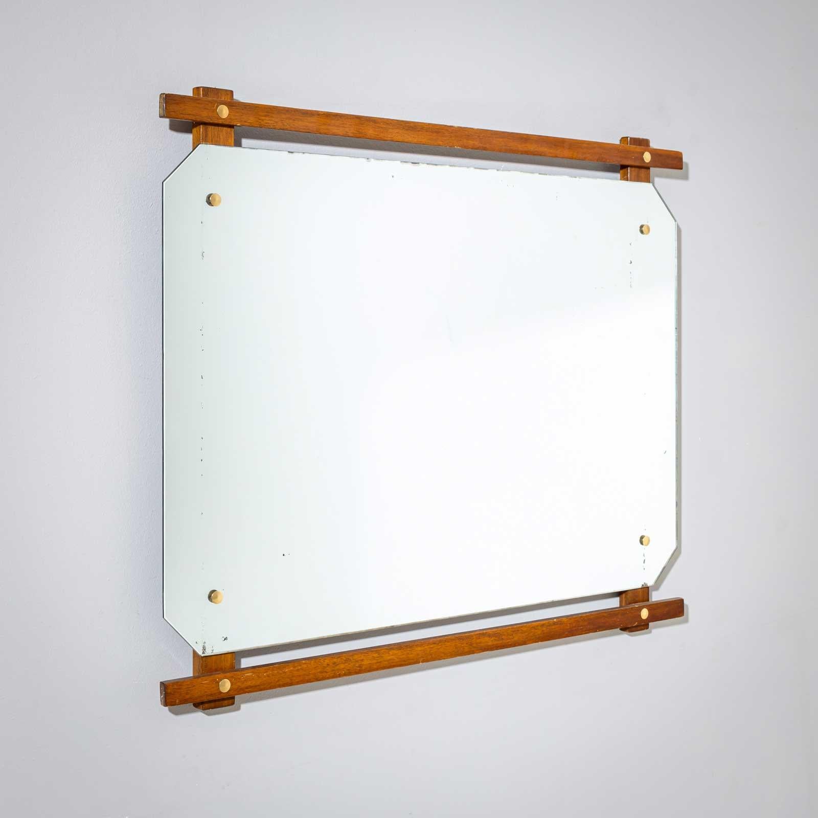 Miroir mural design du milieu du siècle avec deux fines baguettes de bois, rivets en laiton et disque de miroir octogonal. 