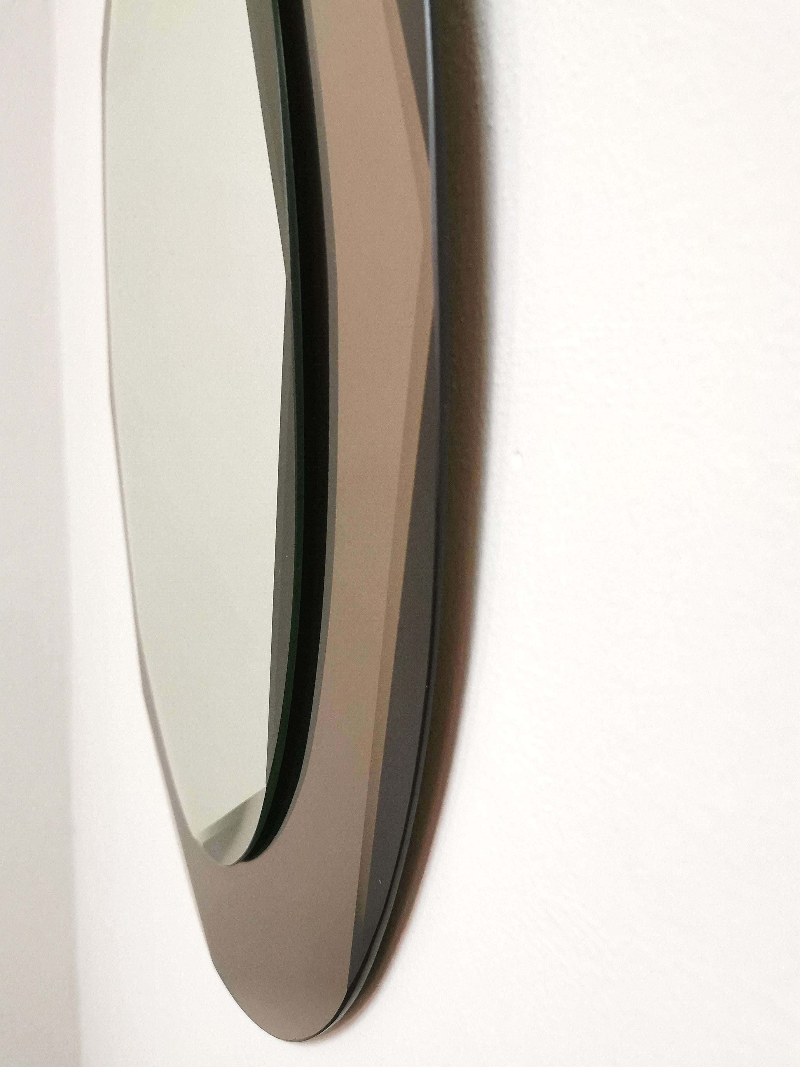Elegant oval-shaped wall mirror with glass plate with rounded corners and mirrored crystal glass in the shade of smoky gray with rounded corners. Made in Italy in the 70s.



Note: We try to offer our customers an excellent service even in shipments