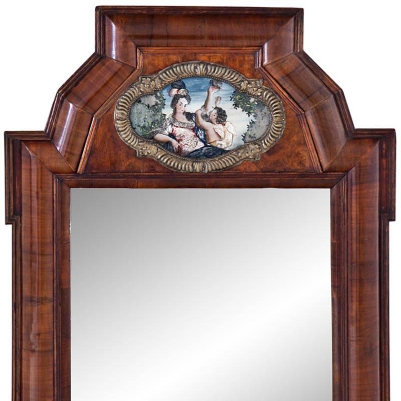 Rectangular wall mirror with a slightly curved walnut frame. The frame shows a polychrome depiction of Venus with cupid in a quatrefoil cartouche.
Size of mirror glass: 40.5 x 35 cm.