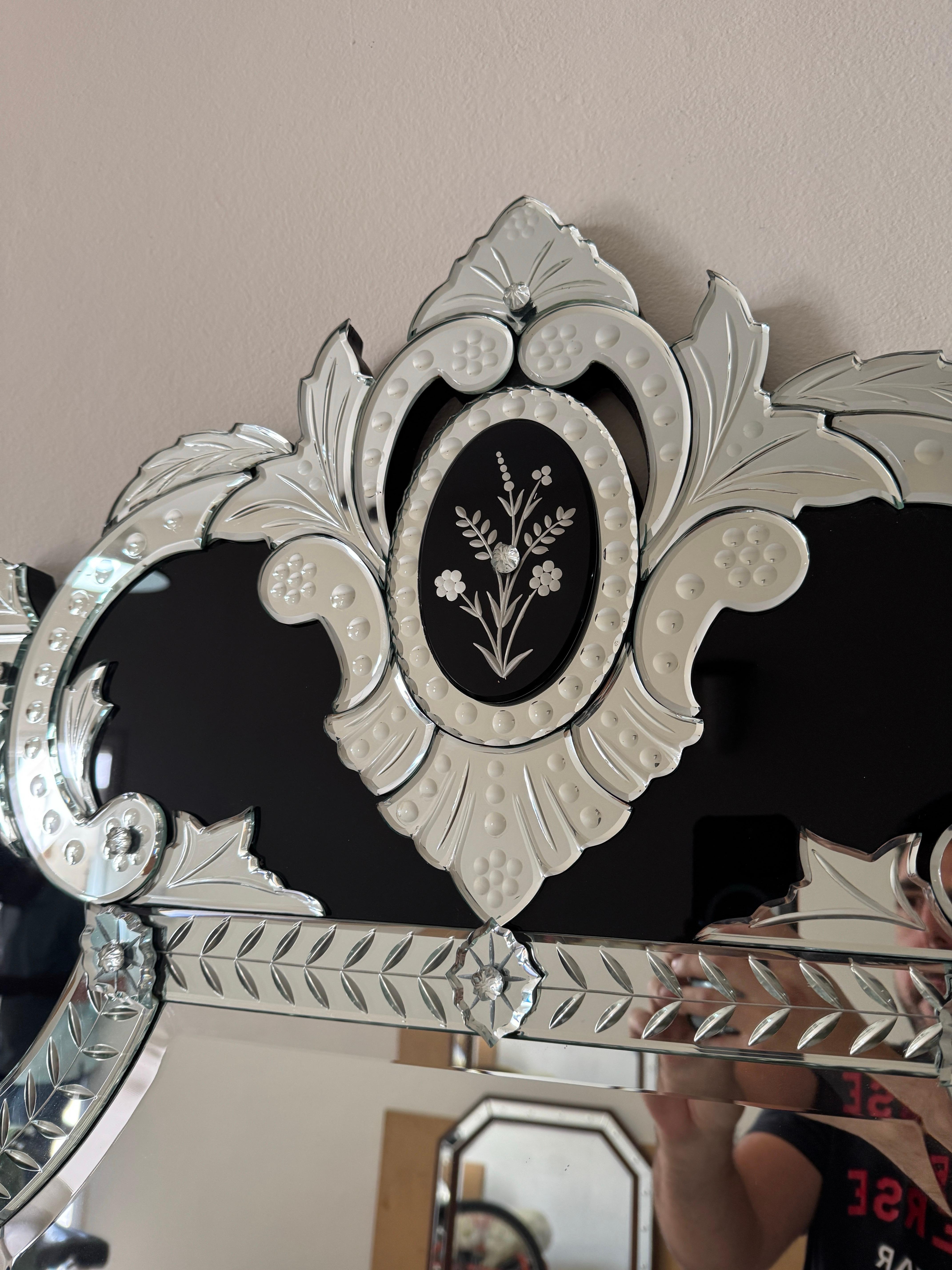 Voici un miroir de style vénitien vraiment exceptionnel, un chef-d'œuvre d'artisanat et d'élégance intemporelle. Ce miroir présente des gravures complexes dans le verre, une marque de fabrique de la verrerie vénitienne, et est rehaussé par des