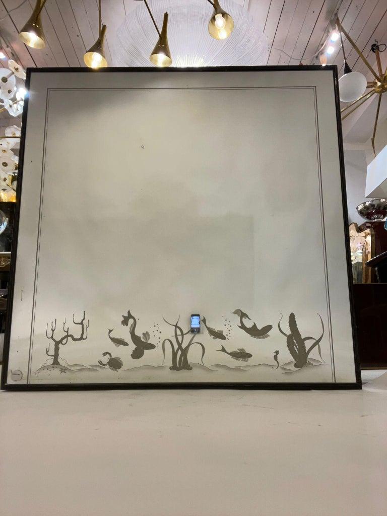 Rare miroir mural décoré d'un précieux fond marin, de diverses espèces de poissons, d'un minuscule hippocampe, d'un crabe curieux, d'herbes marines et de coraux, en verre gravé monté sur un cadre en bois laqué noir, Italie, années 1930.