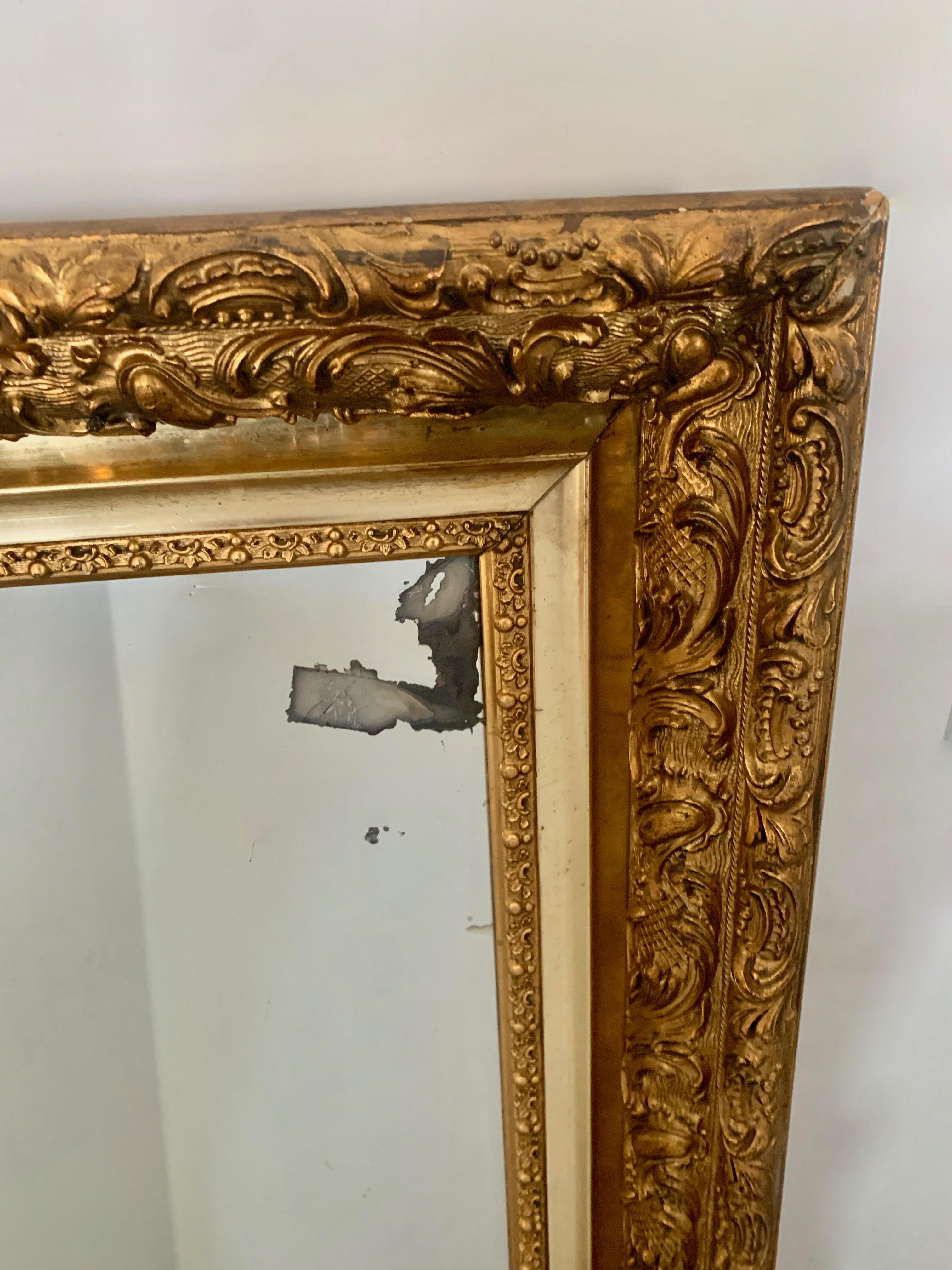 A simple yet wonderful gilt frame wall mirror. The mirror has a few condition issues, which we believe add to the charm... a great piece for a guest room, dressing room or bedroom.