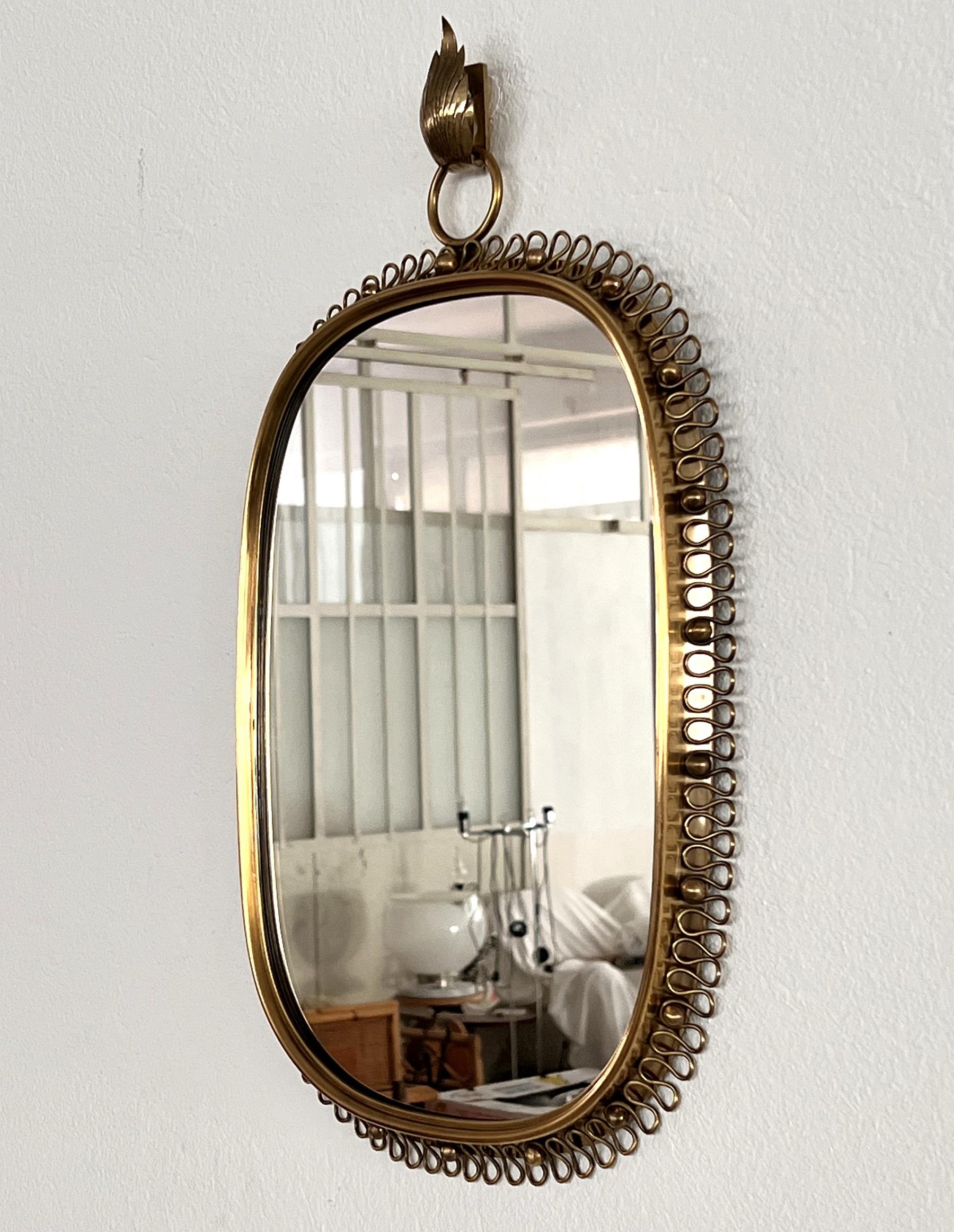 Gorgeous wall mirror with its proper wall hook designed by Austrian Josef Frank and manufactured in Sweden by Svensk Tenn in the midcentury.
This mirror is made of full brass frame with spiral loop frame around and big round hanging loop on top.
You