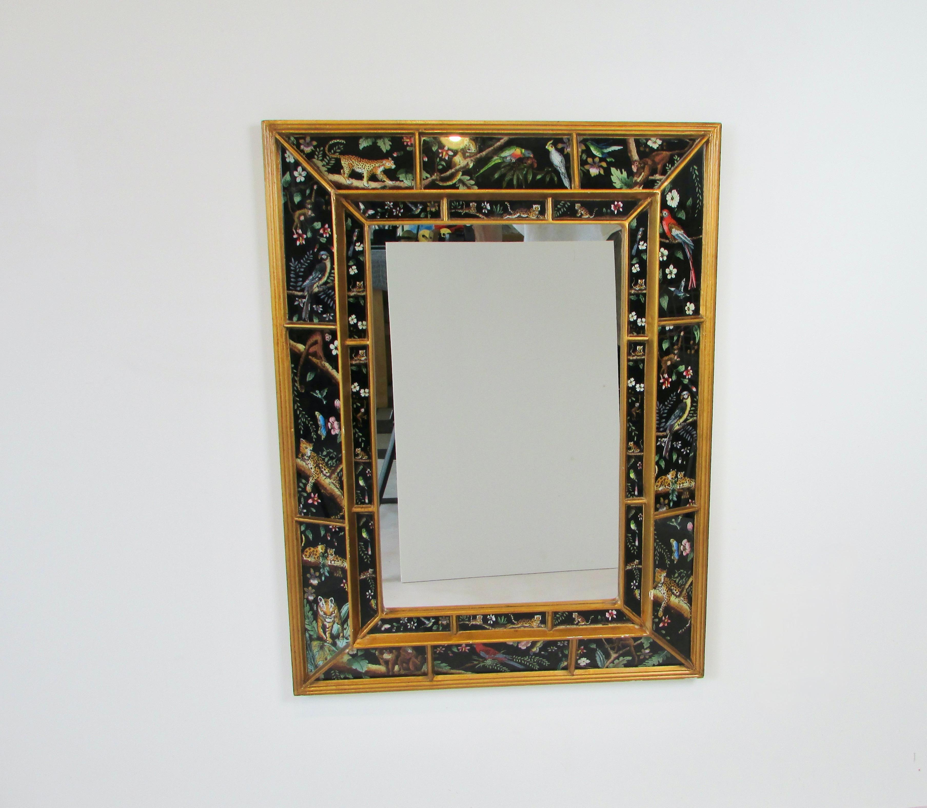Wall mirror framed with vividly depicted exotic jungle animals as at the frame. Tigers panthers monkeys parrots etc. Allbordered in gold leaf.